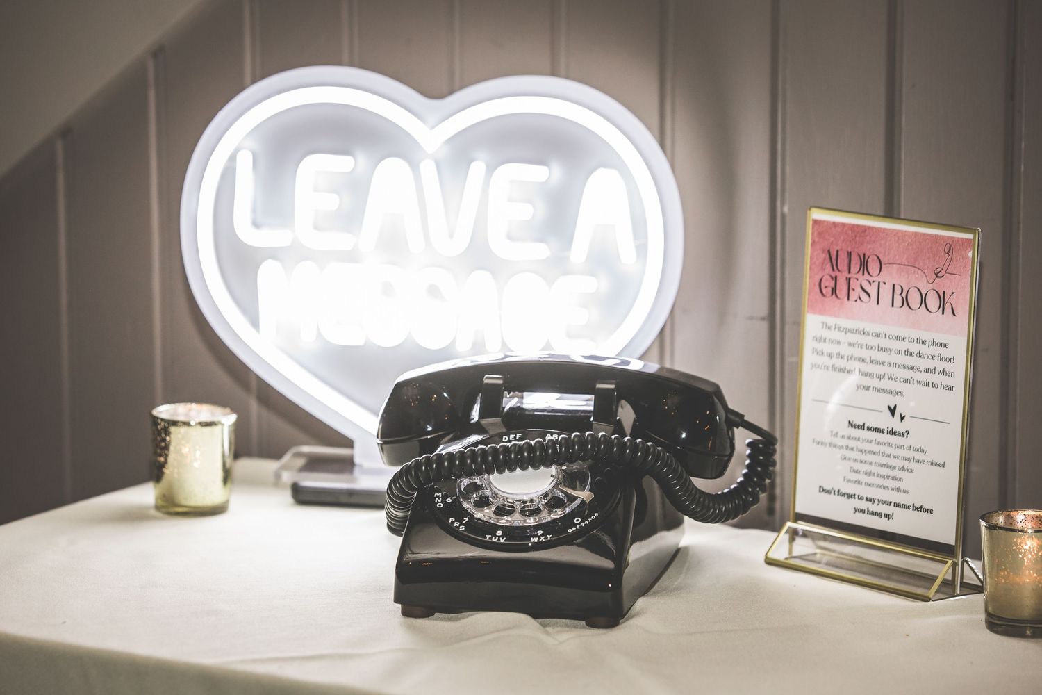 Illuminated heart-shaped signs displayed on dark shelving at wedding venue.