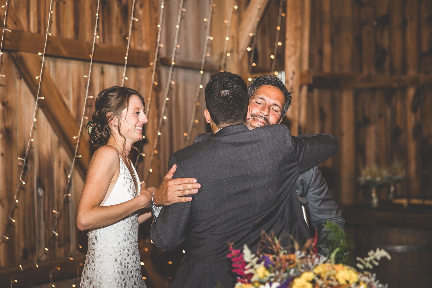 Wedding celebration in a barn venue with string lights creating a warm atmosphere.