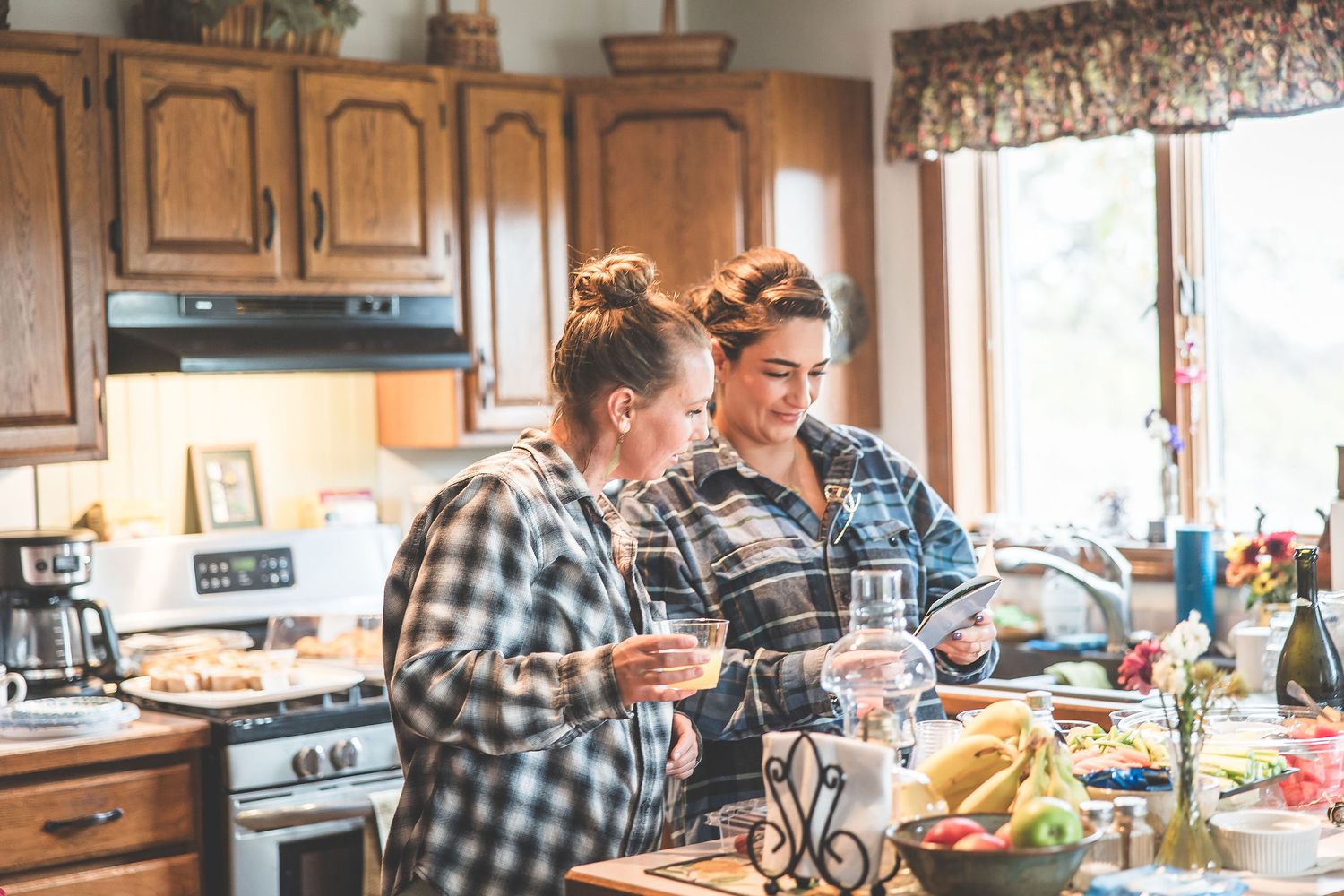 A kitchen gathering shows people preparing food and socializing in a casual home setting.
