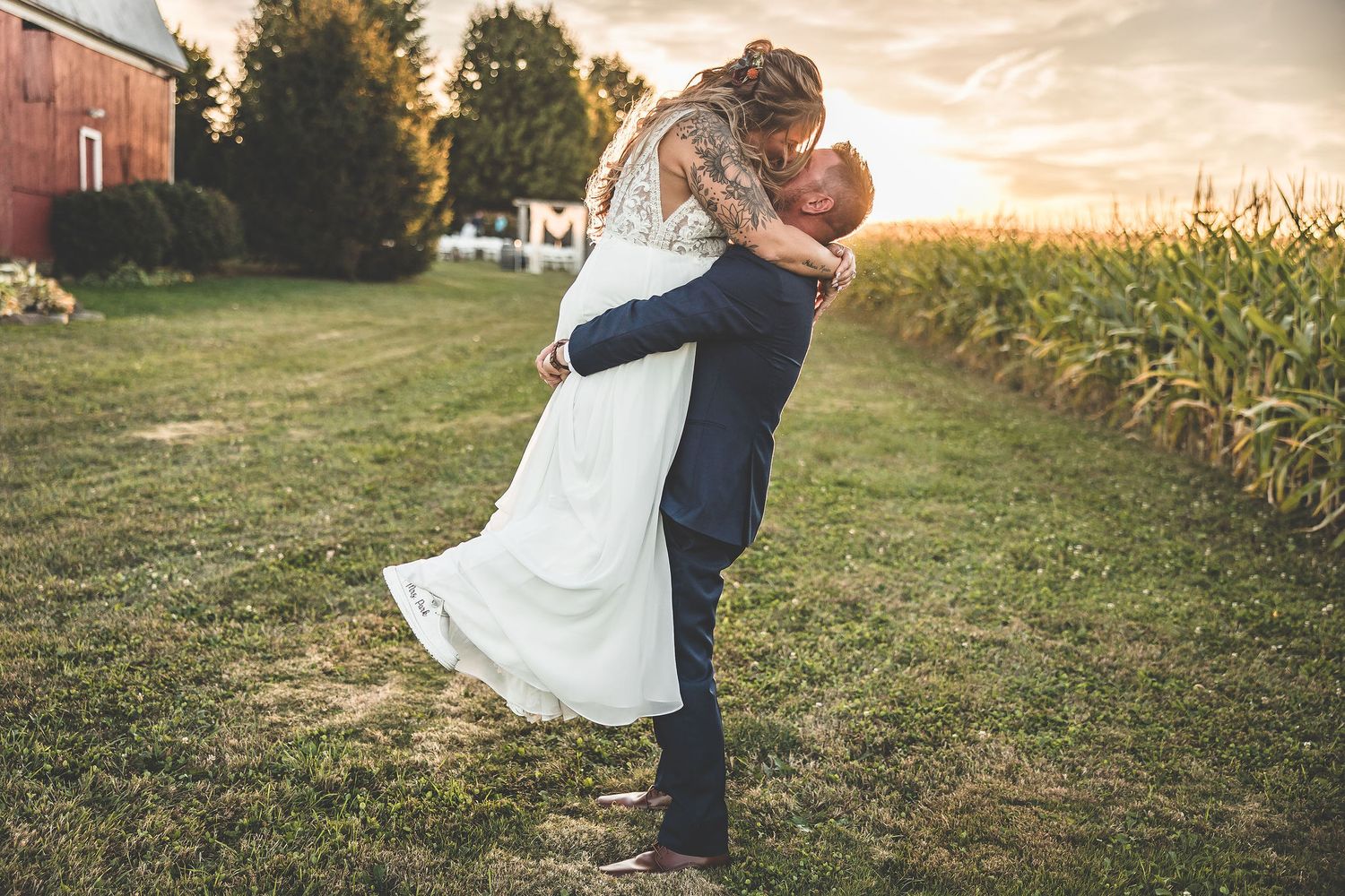 Sunset wedding portraits in a grassy field with golden hour lighting.