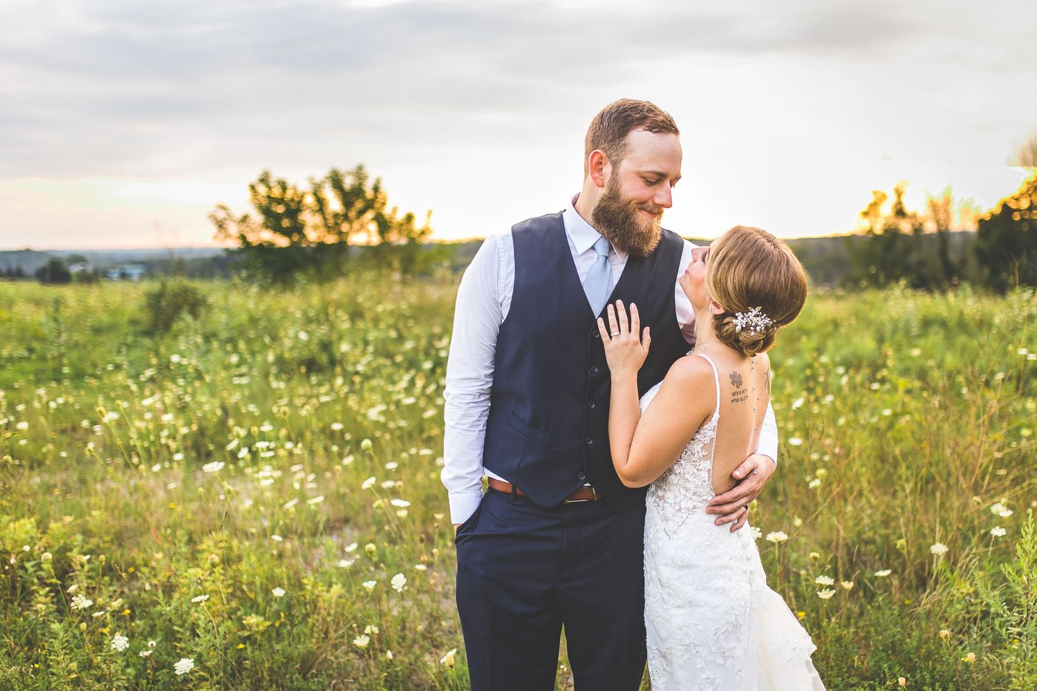 Wedding couple shares intimate dance moves in a sunlit field of flowers.