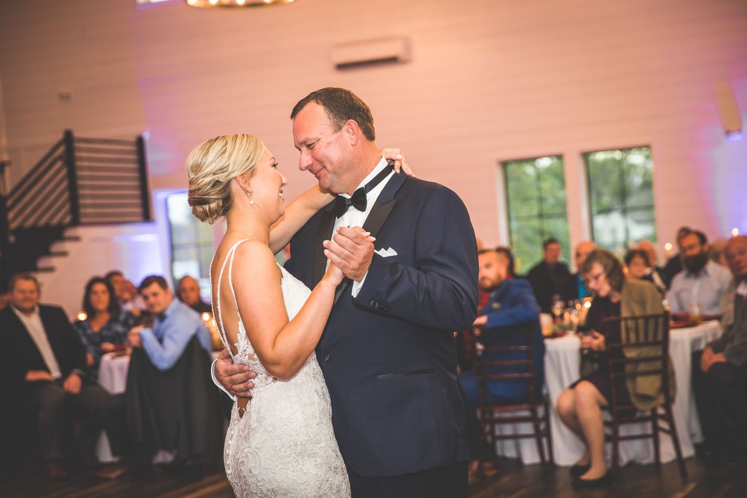 Romantic first dance moments captured in warm lighting at an elegant wedding reception.