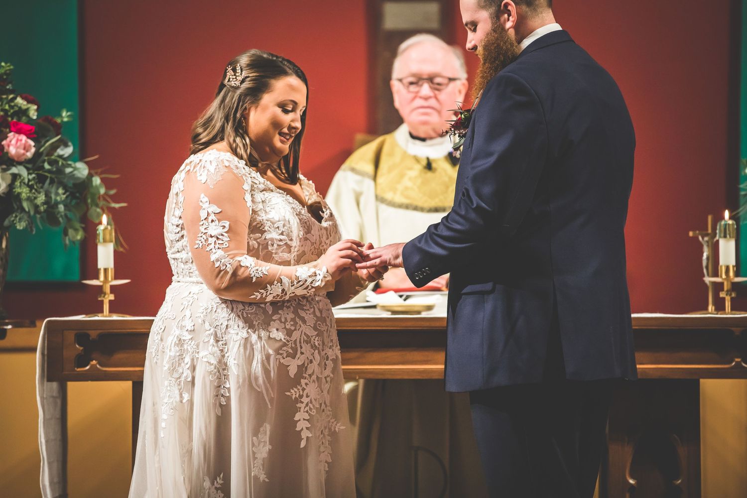 Wedding ceremony in a church with red walls and decorative elements.