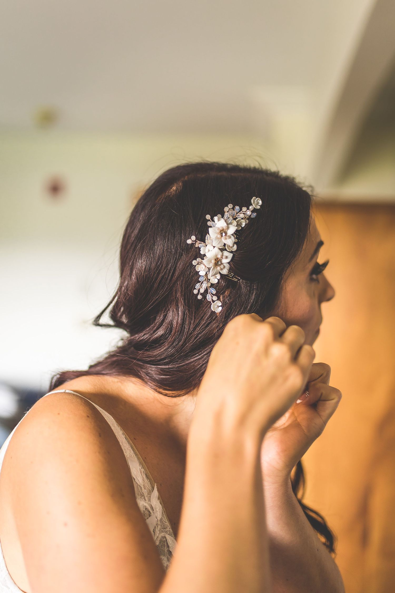 Delicate pearl hair accessory adorns a wedding hairstyle against a soft background.