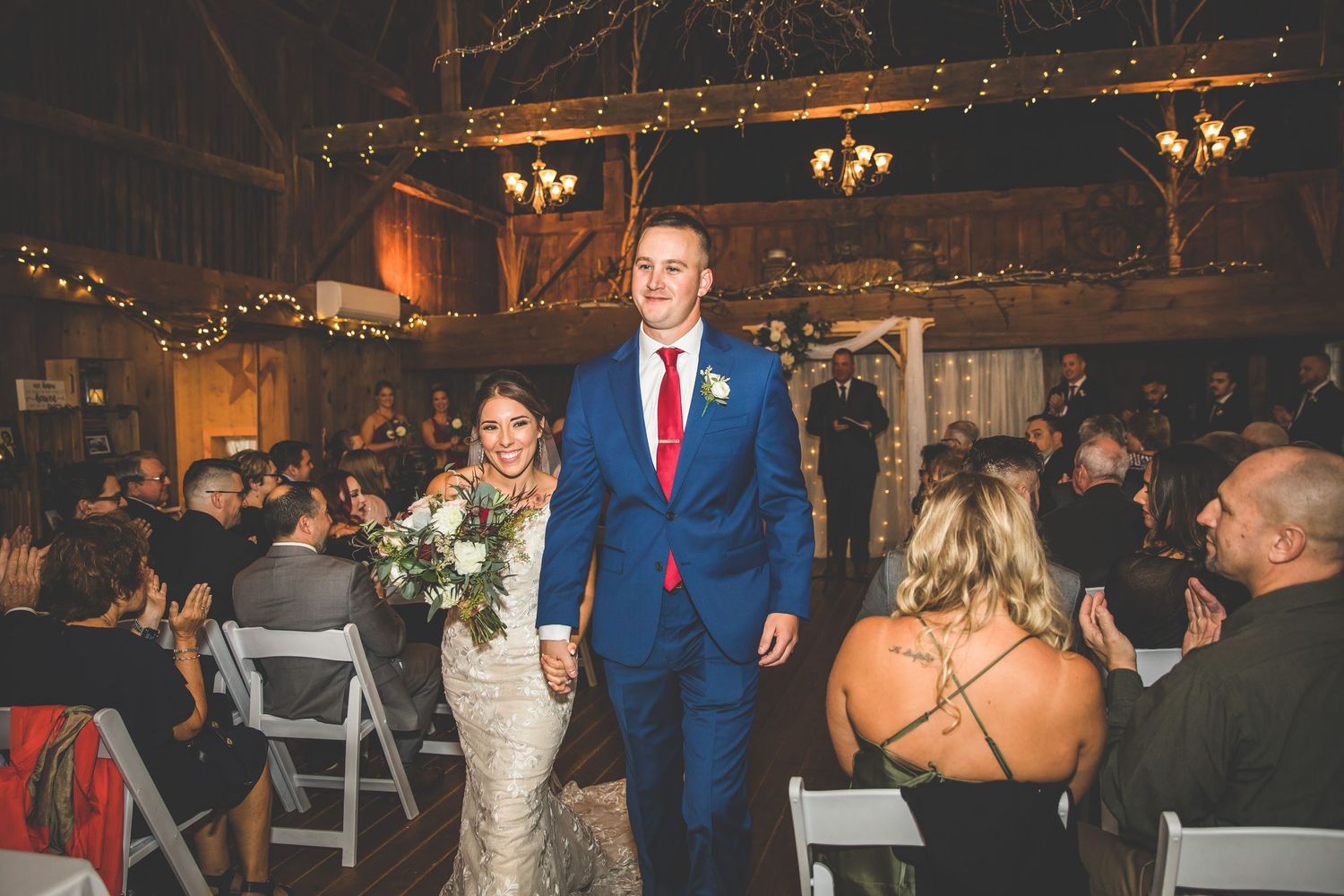 Wedding reception dance floor with string lights and rustic barn decor creating a warm atmosphere.