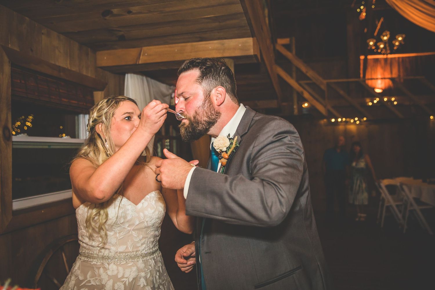 Wedding cake cutting ceremony captured in a series of candid moments at rustic reception.