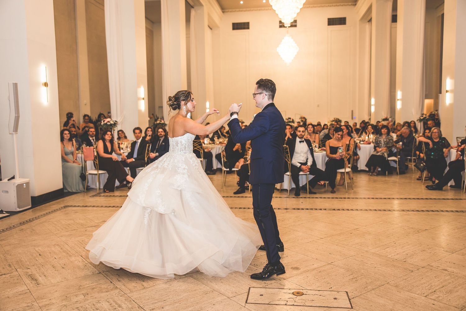 Bride's white gown twirls gracefully during ballroom dance performance.