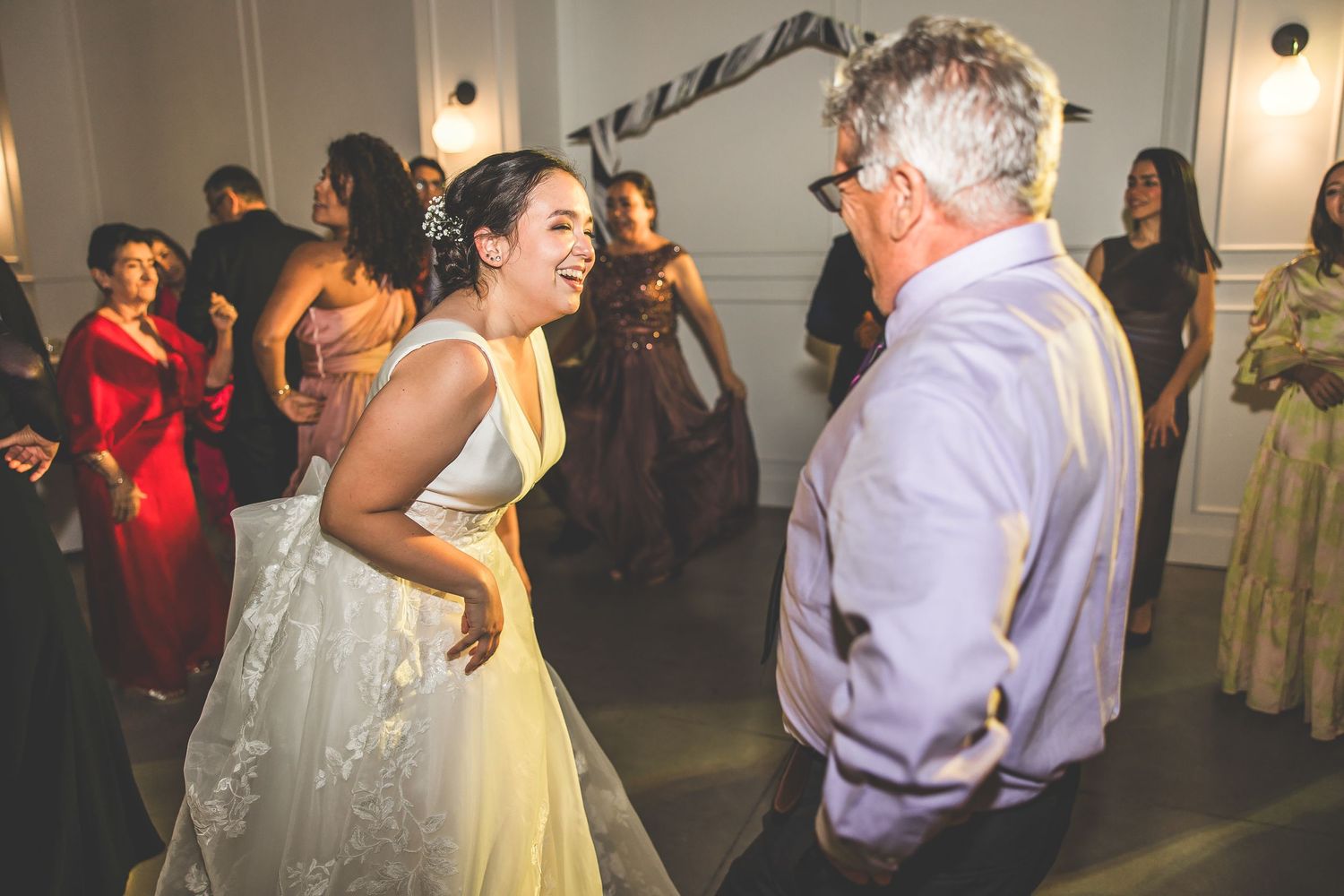 Wedding guests enjoying themselves on the dance floor during an evening celebration.