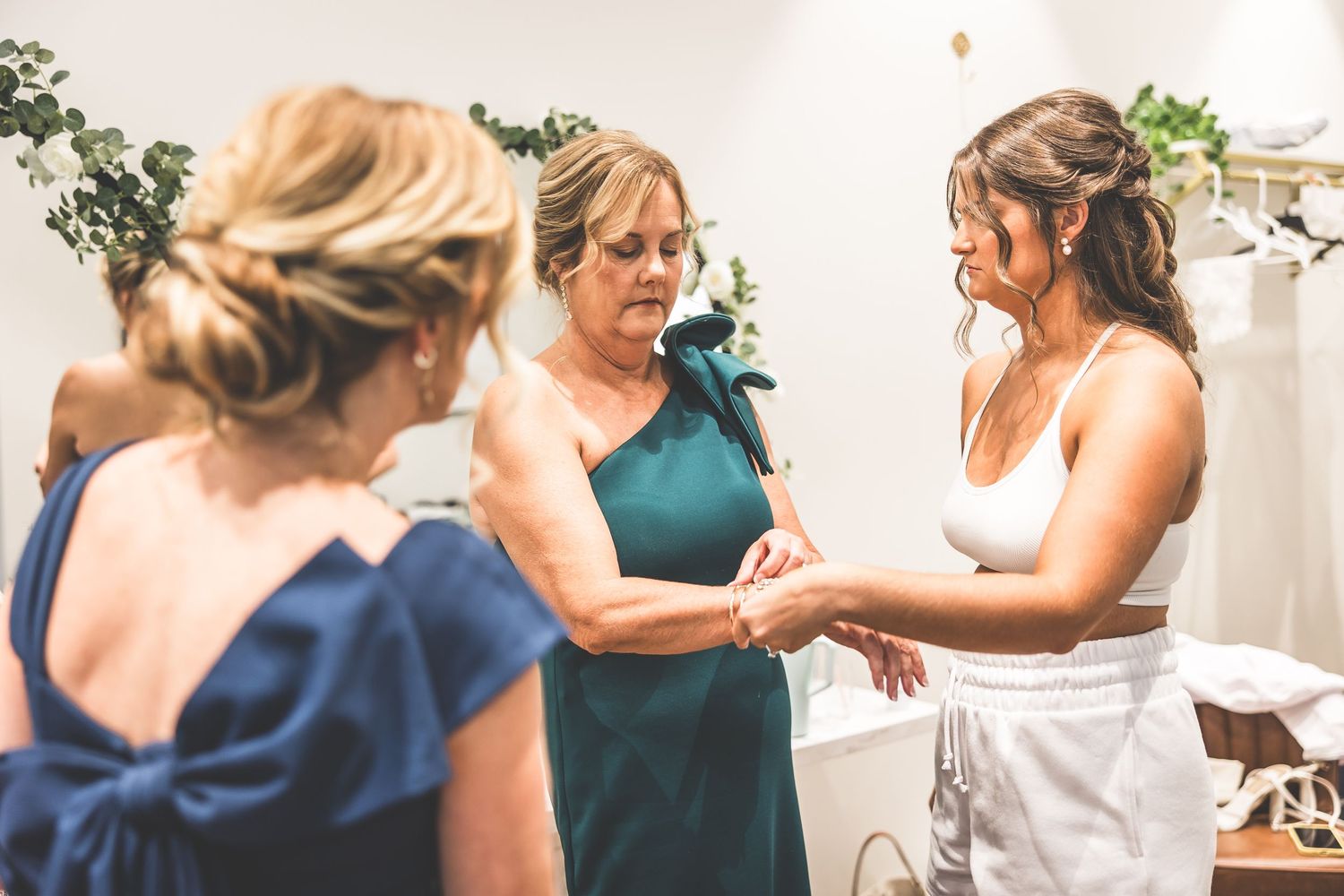 Wedding party members in navy and white dresses share a candid moment together.