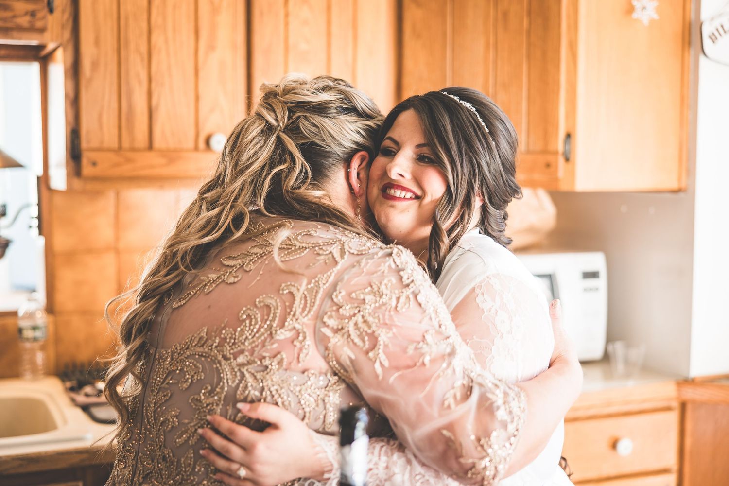 Intimate wedding preparation moment in a warm-lit room with lace details.