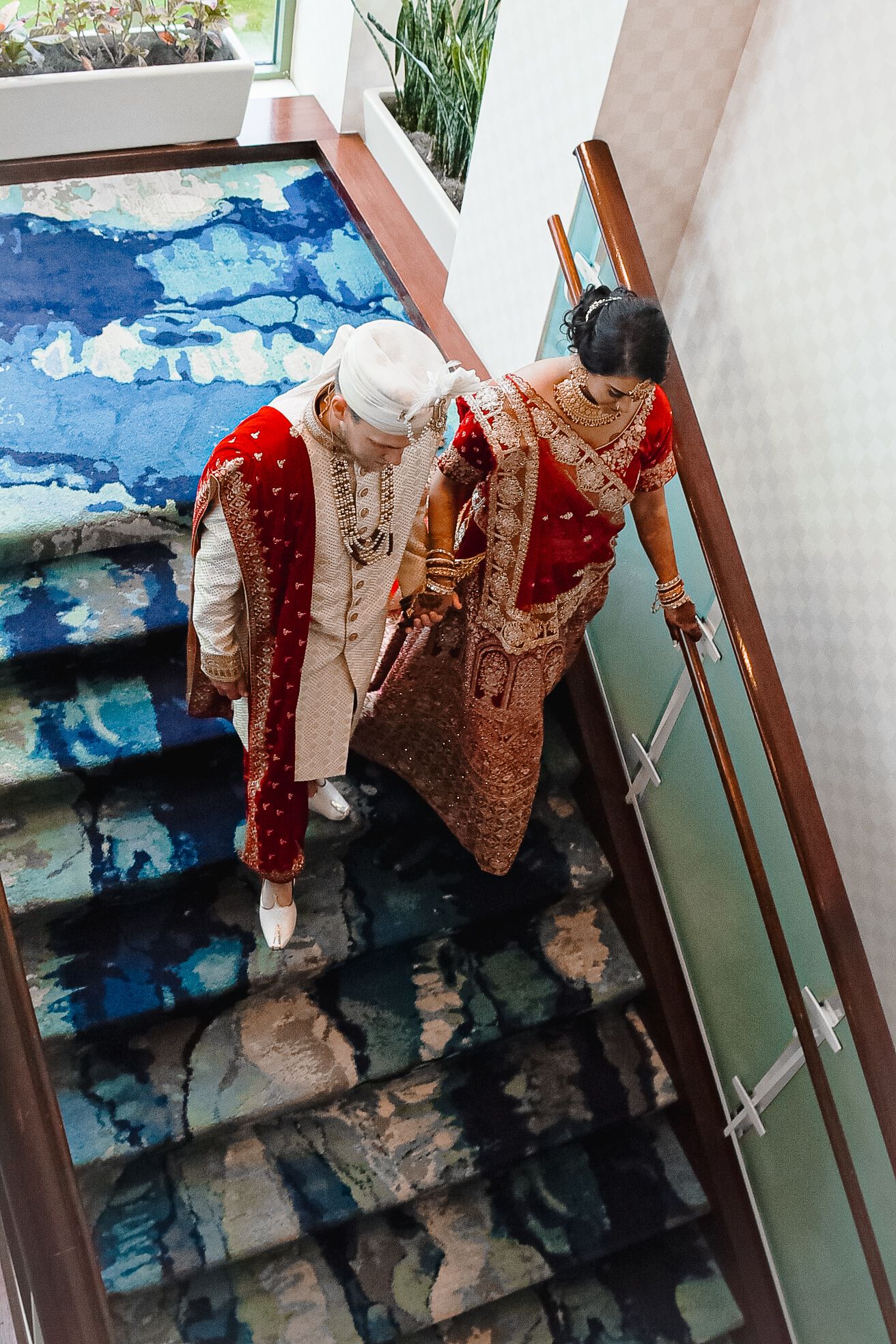 Wedding attire displayed on hangers against blue watercolor backdrop.
