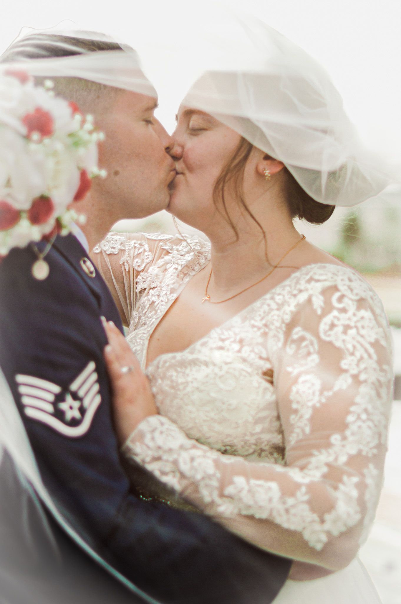 A romantic wedding kiss sequence showing a couple in traditional white dress and navy uniform.