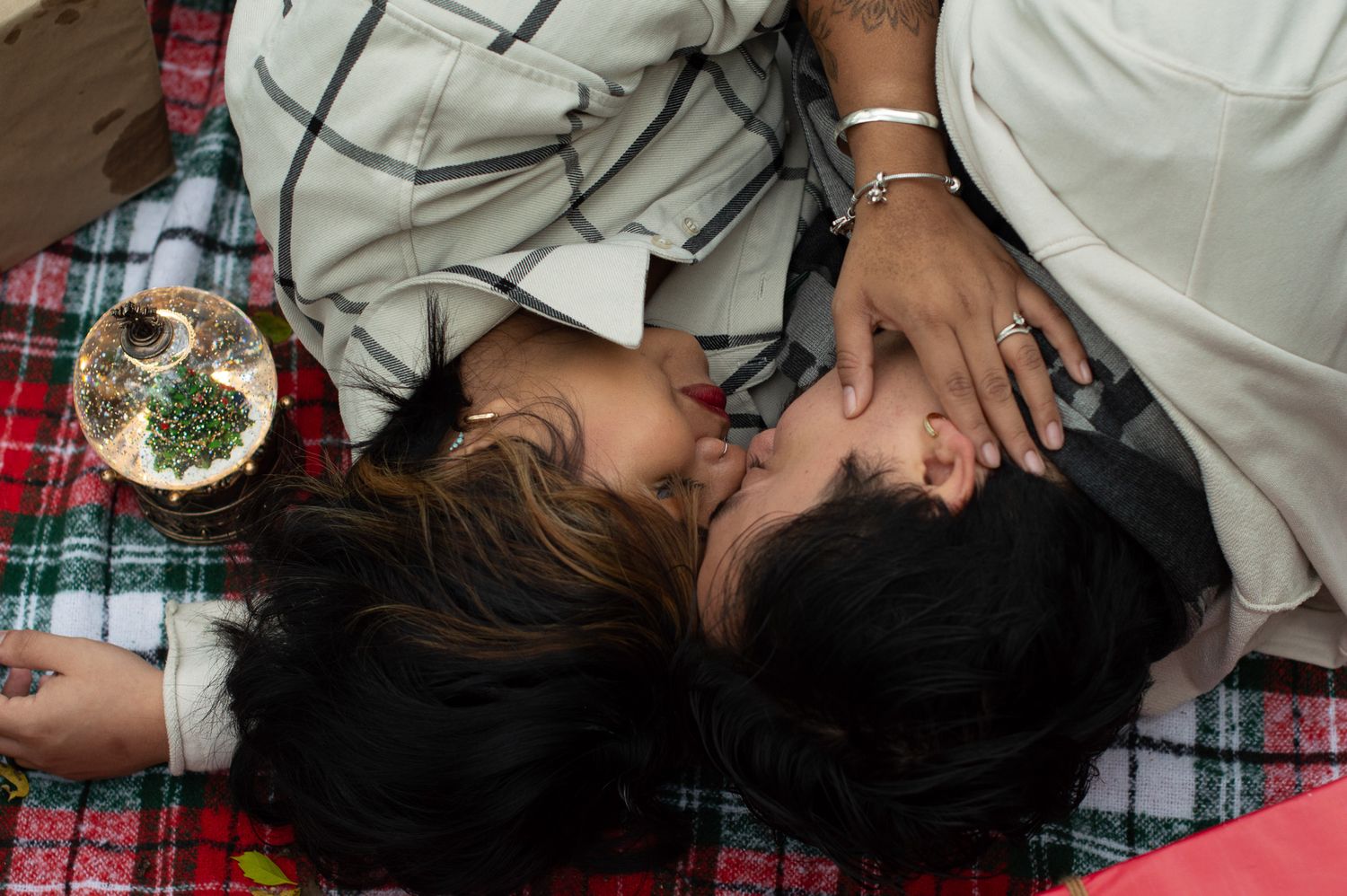 Candid family moment captured on a plaid blanket outdoors.