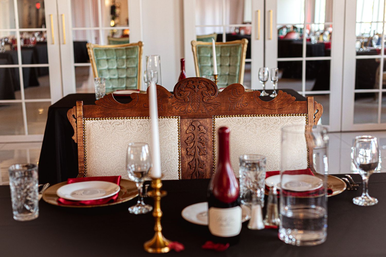 Vintage-style place settings with wine glasses and china on elegant dining tables.
