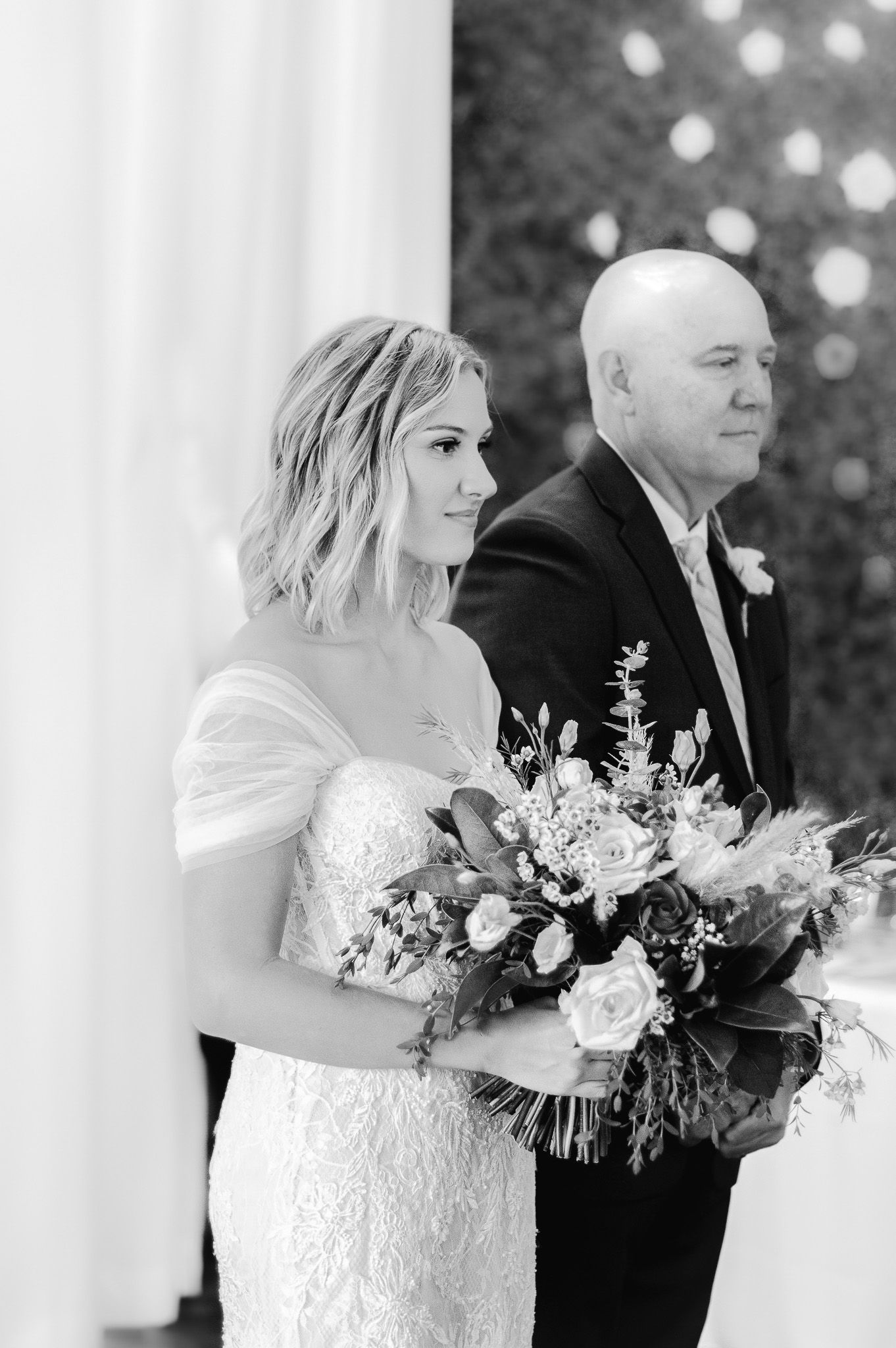 Black and white portrait of couple with elegant winter wedding bouquet.