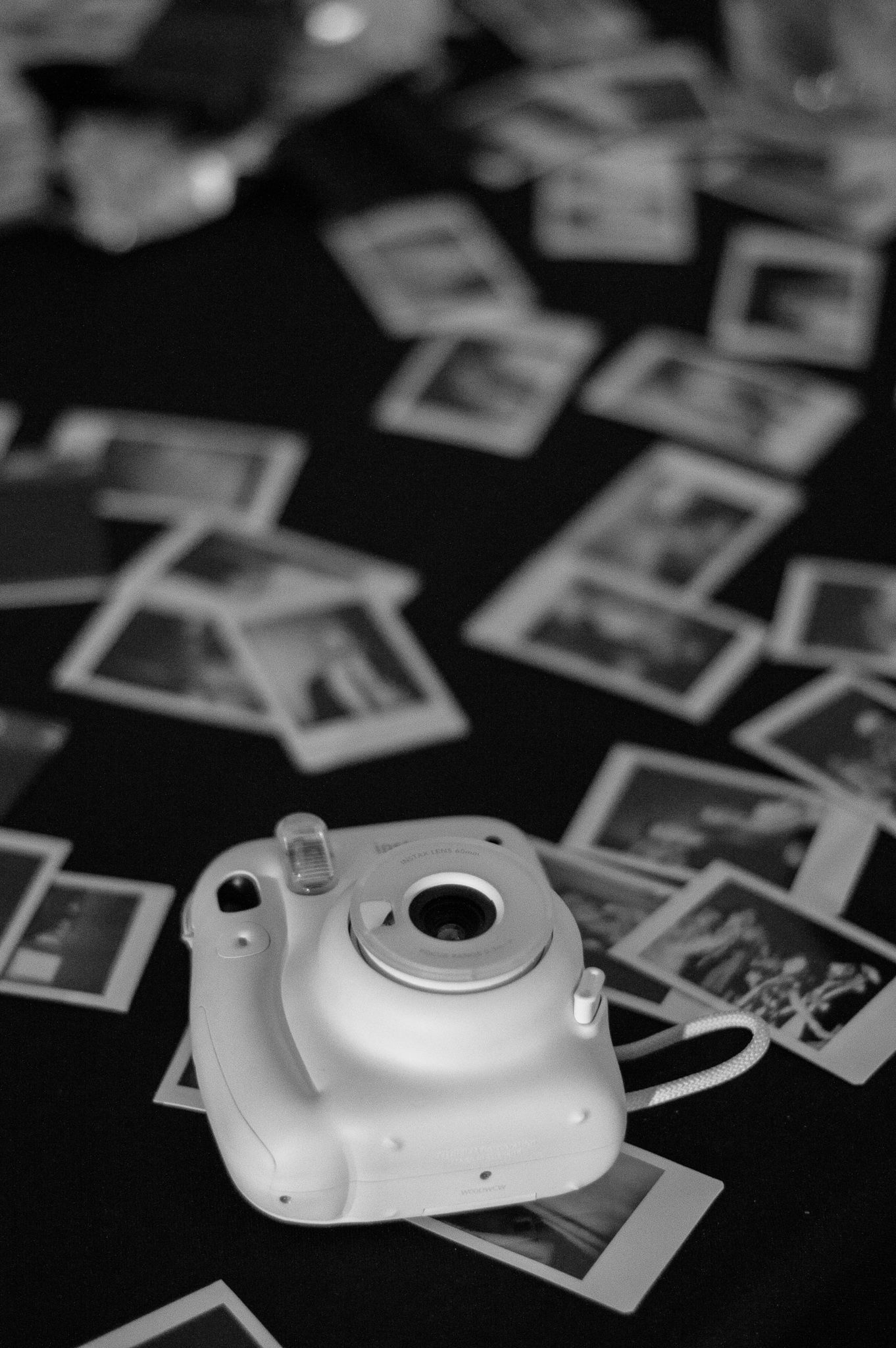 Black and white composition of vintage polaroid photos and camera equipment.