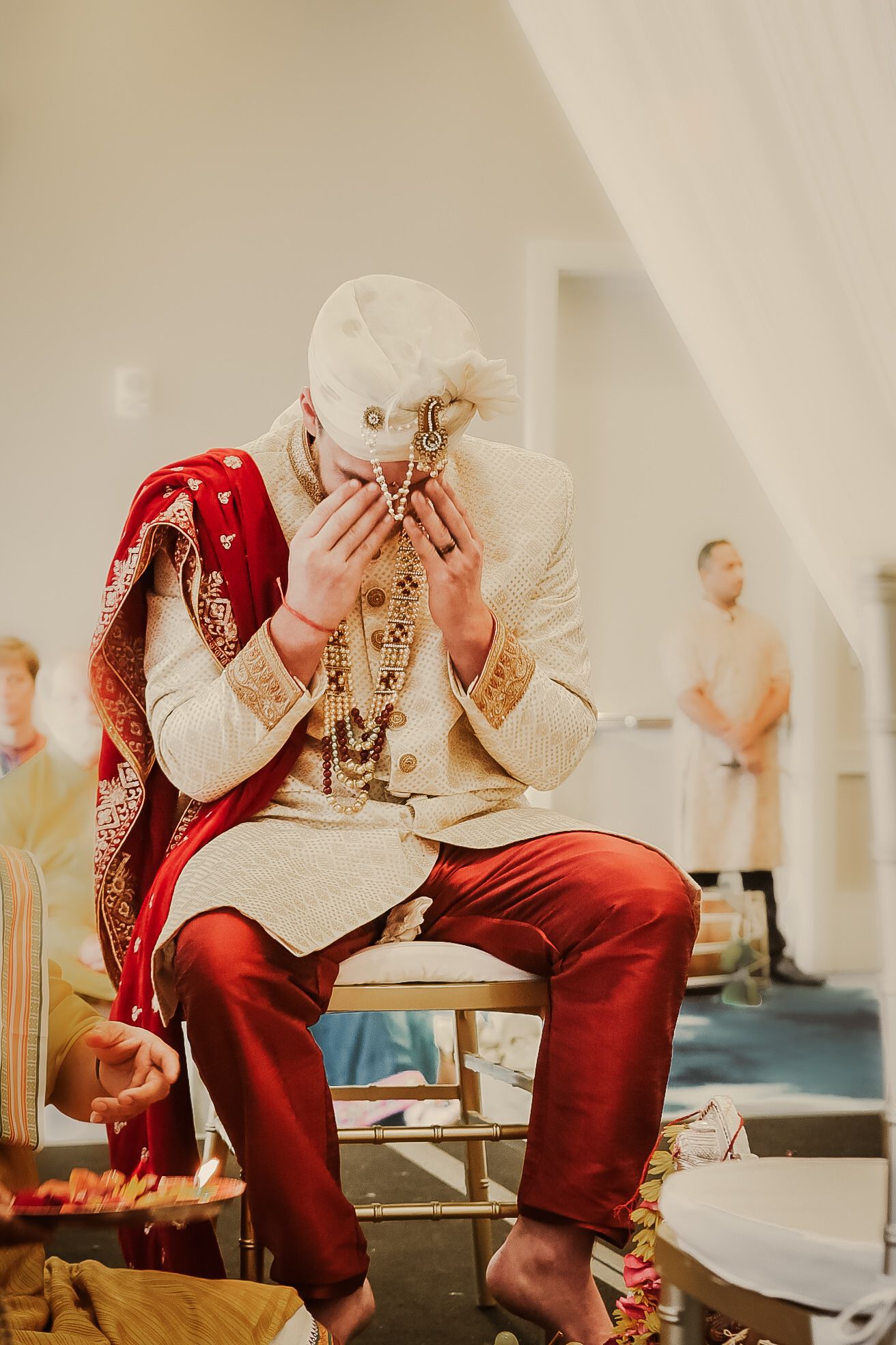 Wedding attire in rich red and cream colors displayed in an elegant setting.