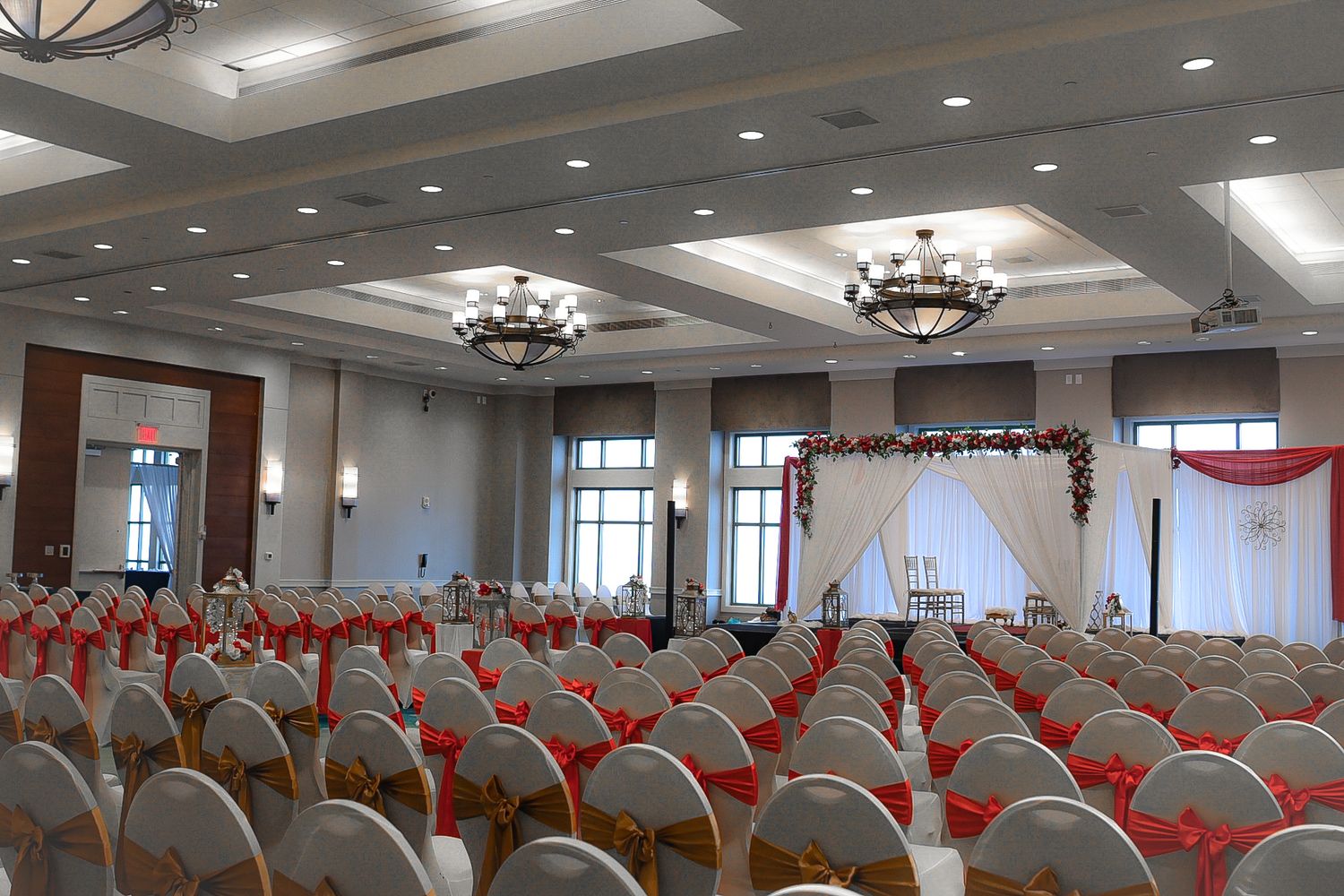 Large banquet hall set up with rows of chairs and elegant chandeliers for a formal event.