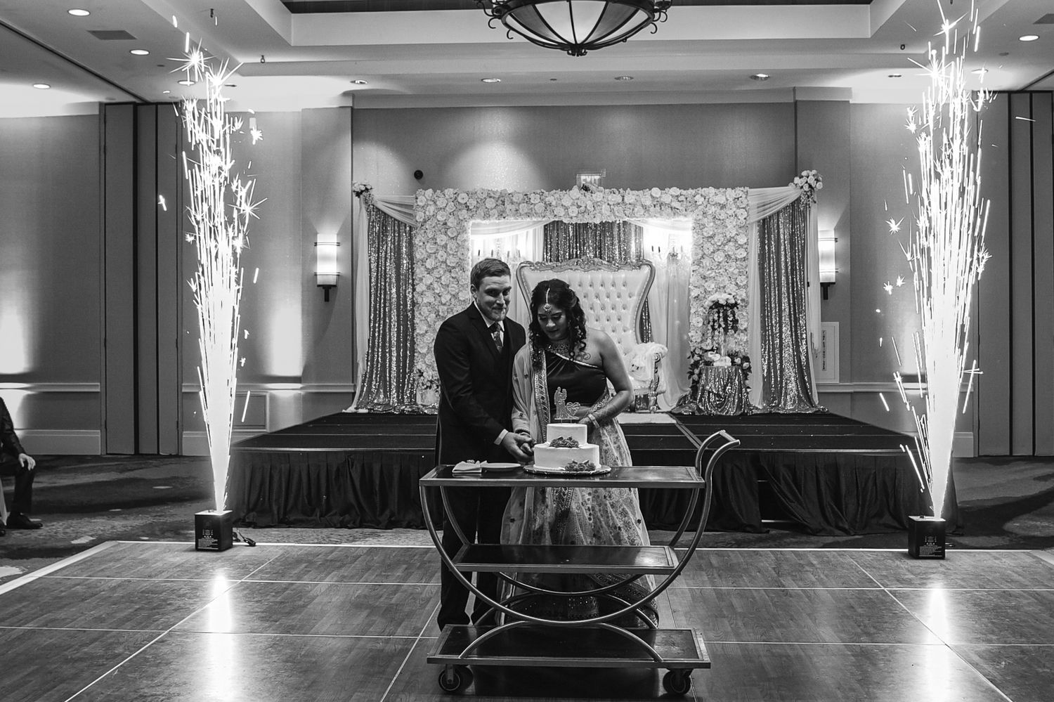Black and white wedding reception with dramatic sparkler effects and dance floor.