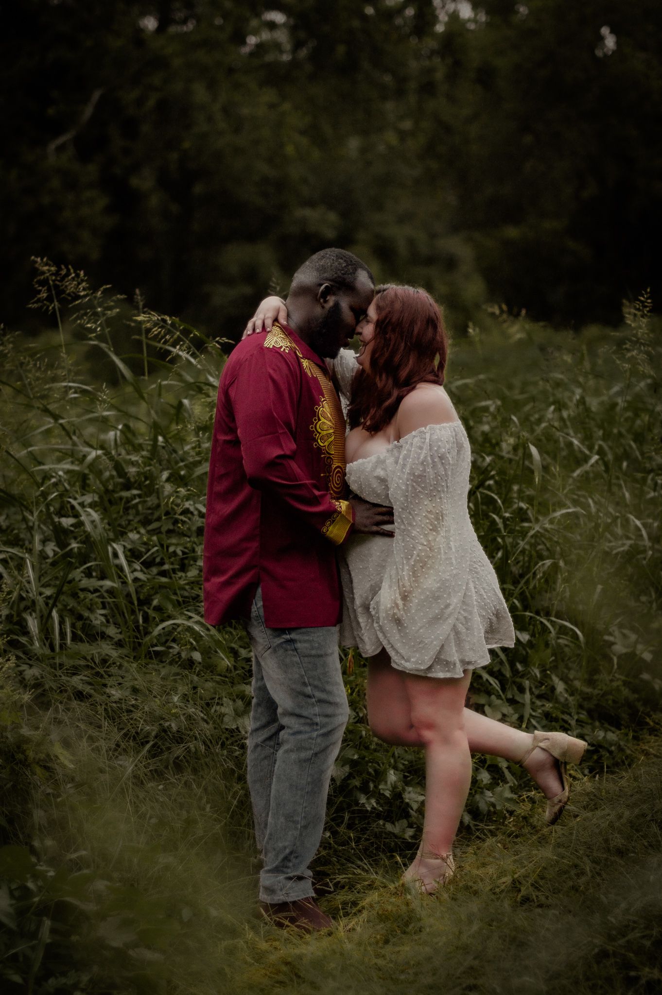Romantic couple photoshoot in a tall grass field at dusk.
