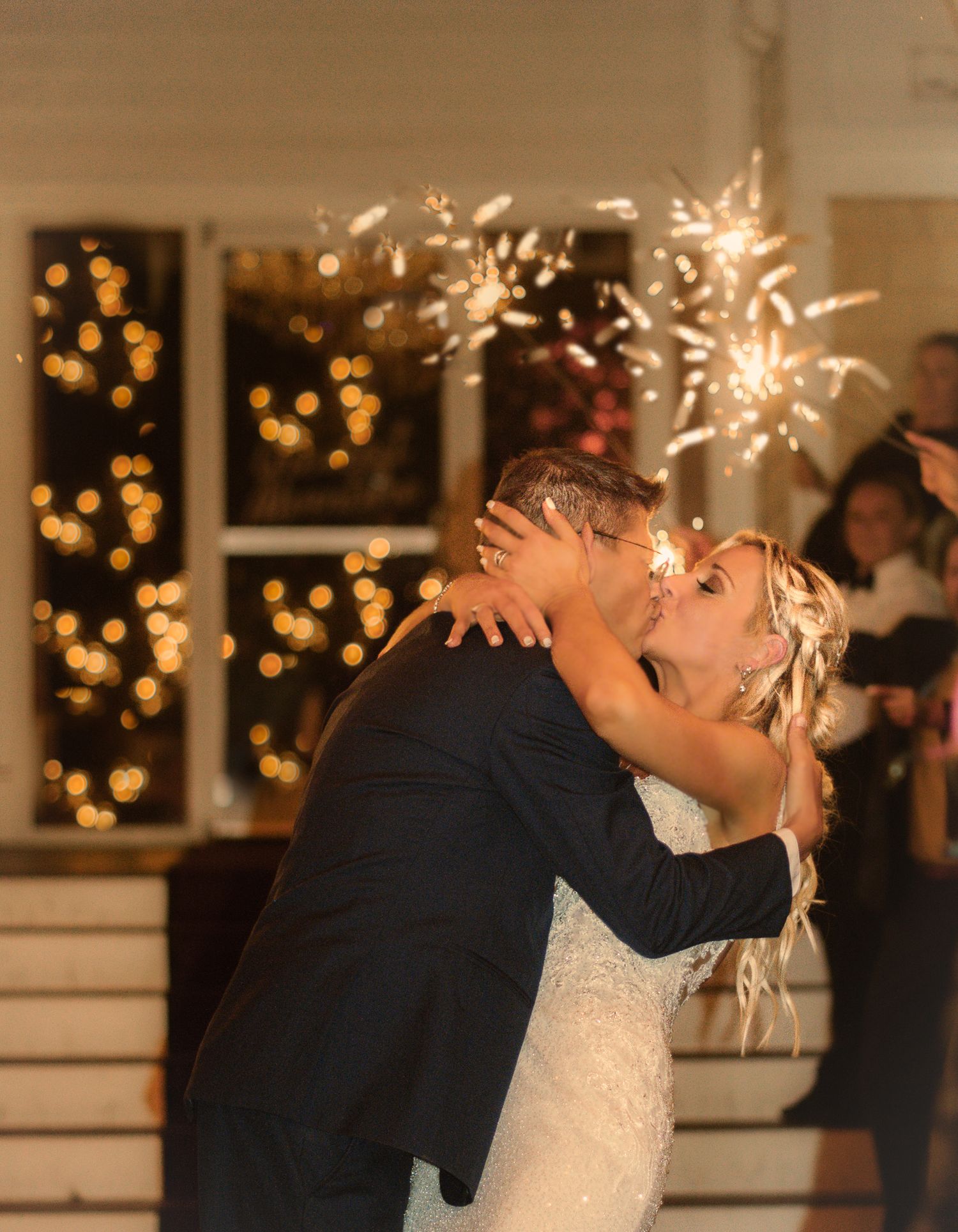 Wedding couple dancing with sparklers creating magical light trails.