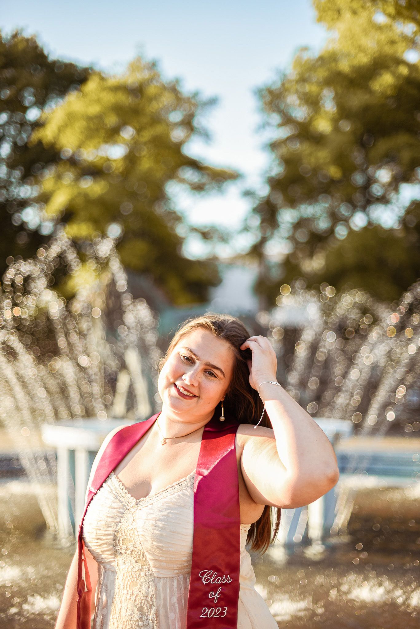 A joyful moment captured in front of a fountain on a sunny day.