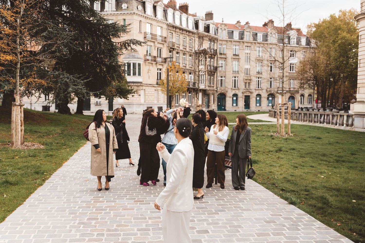 Bride throwing her bouquet to her elegant female friends in Lilli in France. Destination wedding.