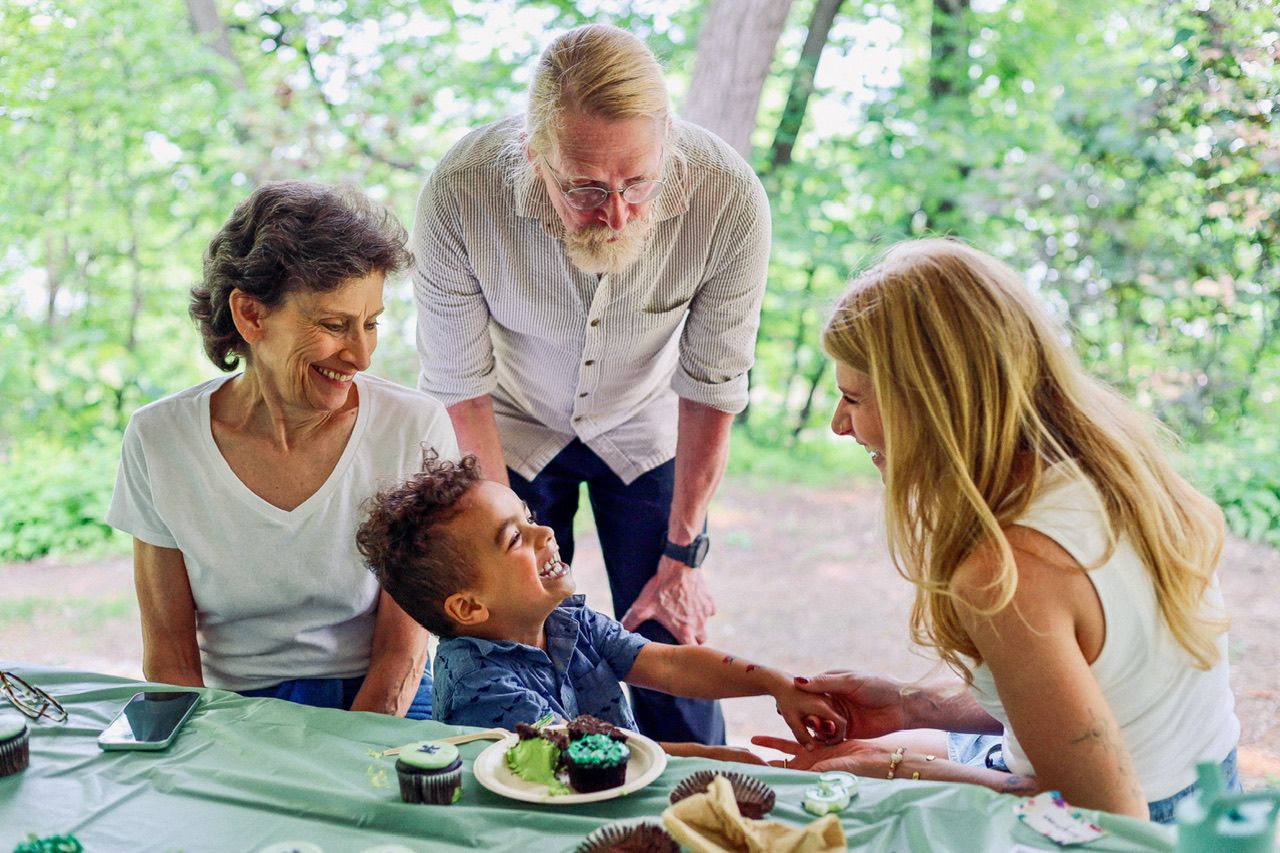 People gathered together outdoors enjoying a casual picnic in a park setting.