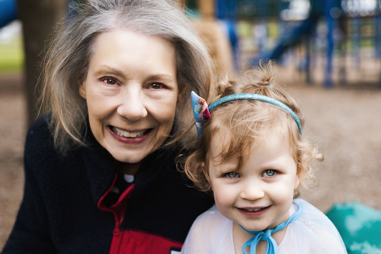 A cheerful family moment captured at a playground on a sunny day.