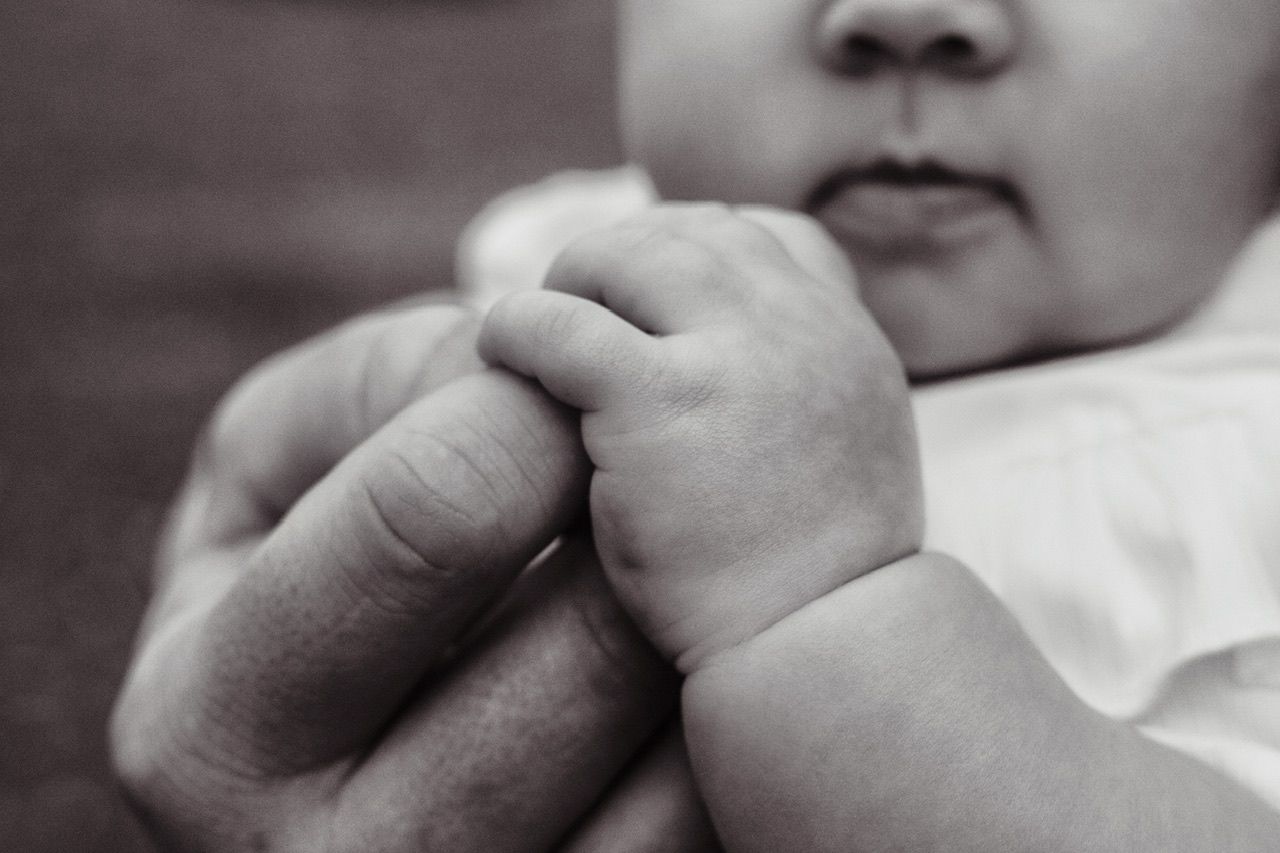 Black and white close-up photograph showing gentle interaction between two people.