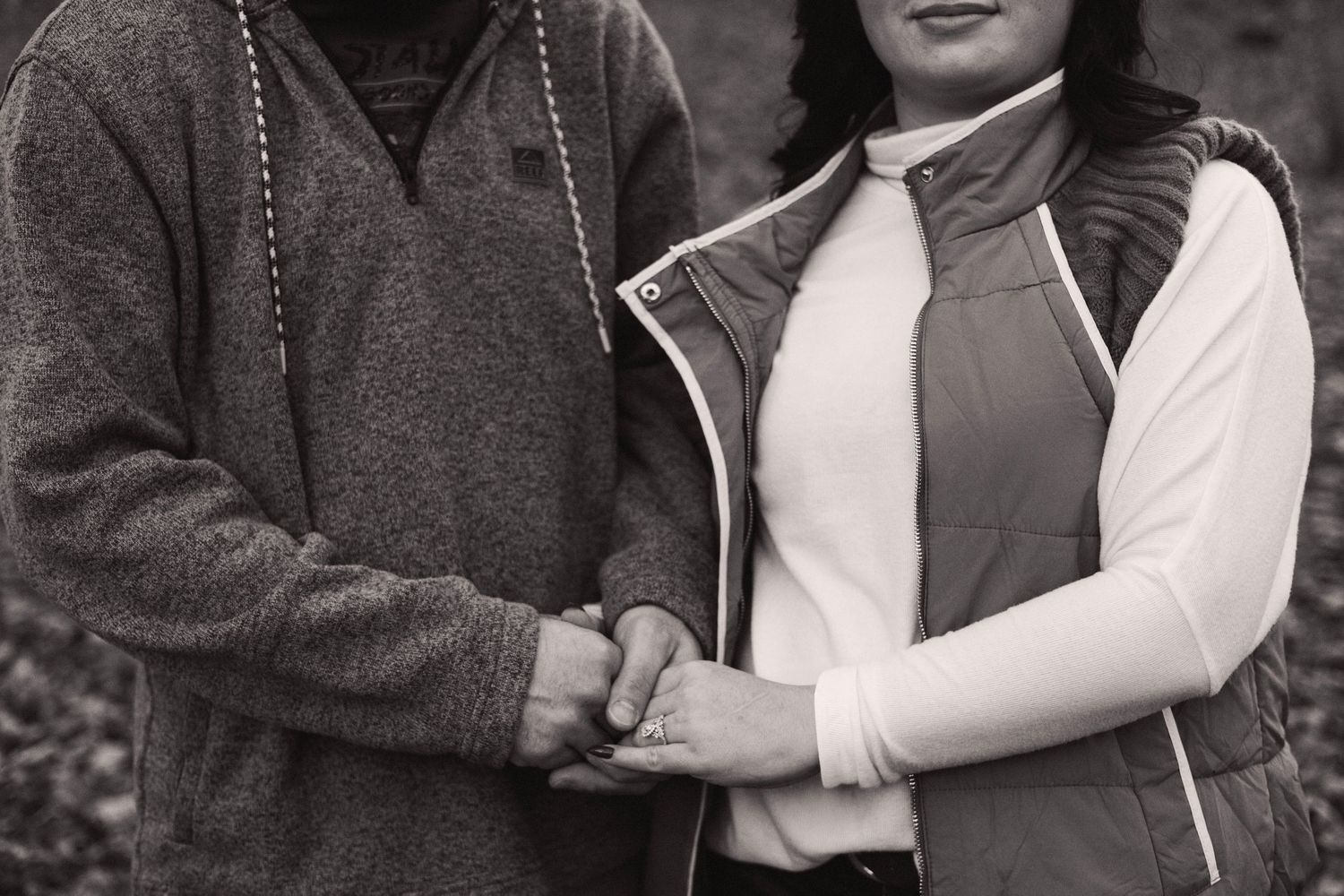 Intimate black and white portrait of a couple embracing outdoors.