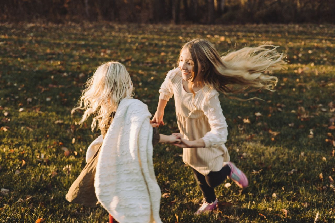 Golden autumn sunlight illuminates a grassy field during a sunset photo session.