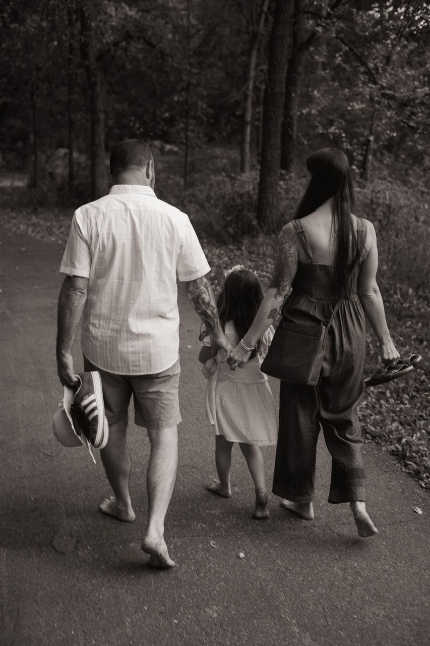 Black and white image sequence of people walking together on a forest path.