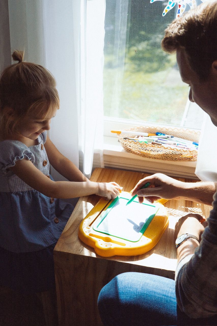 A series showing children working on art or educational activities at a wooden table near a window.