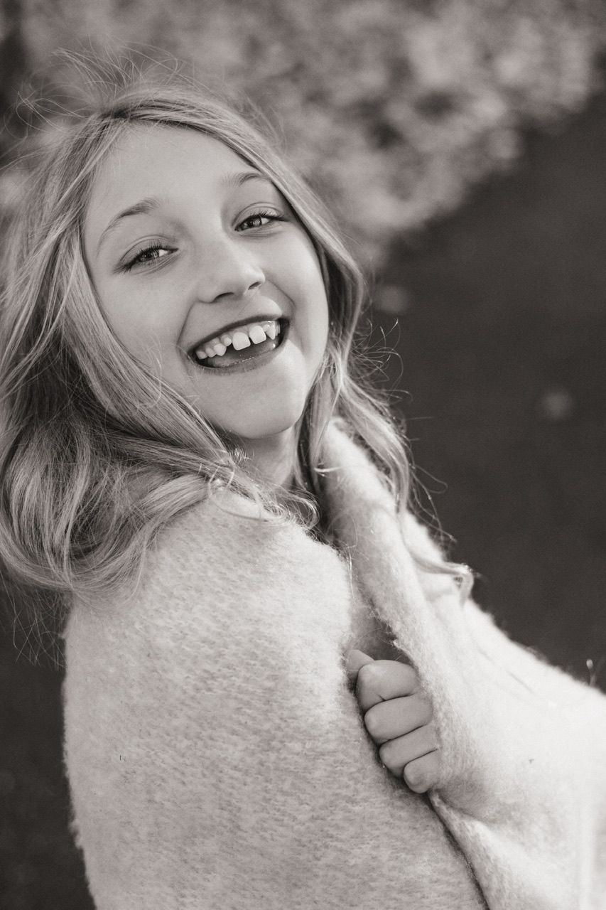 Black and white portrait series showing playful expressions and cozy winter wear.