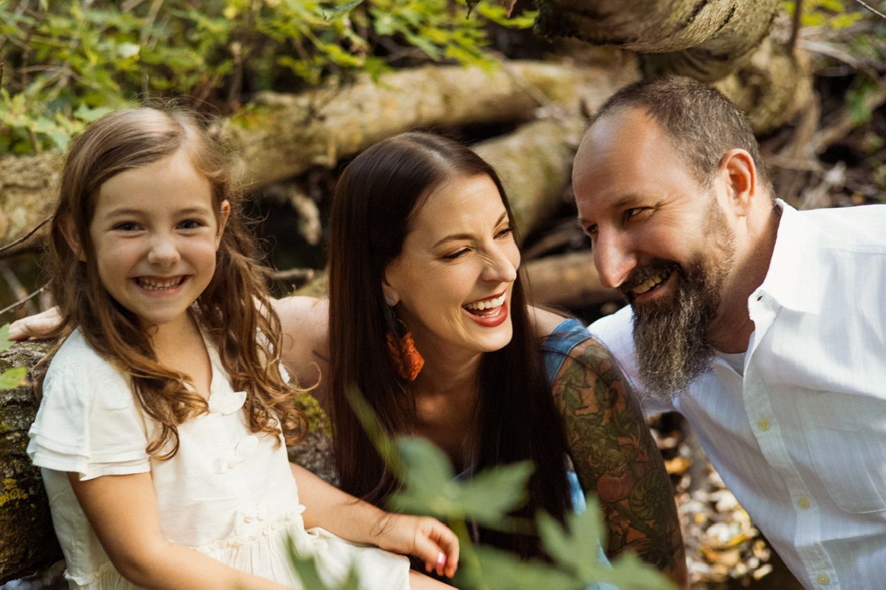 A family shares intimate moments together while relaxing in a natural outdoor setting.