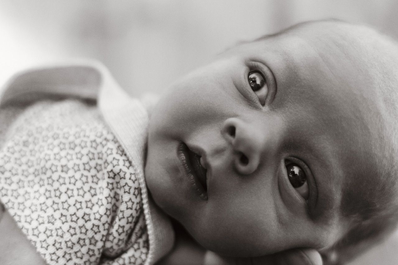 Artistic black and white close-up of a baby's face with striking eyes.