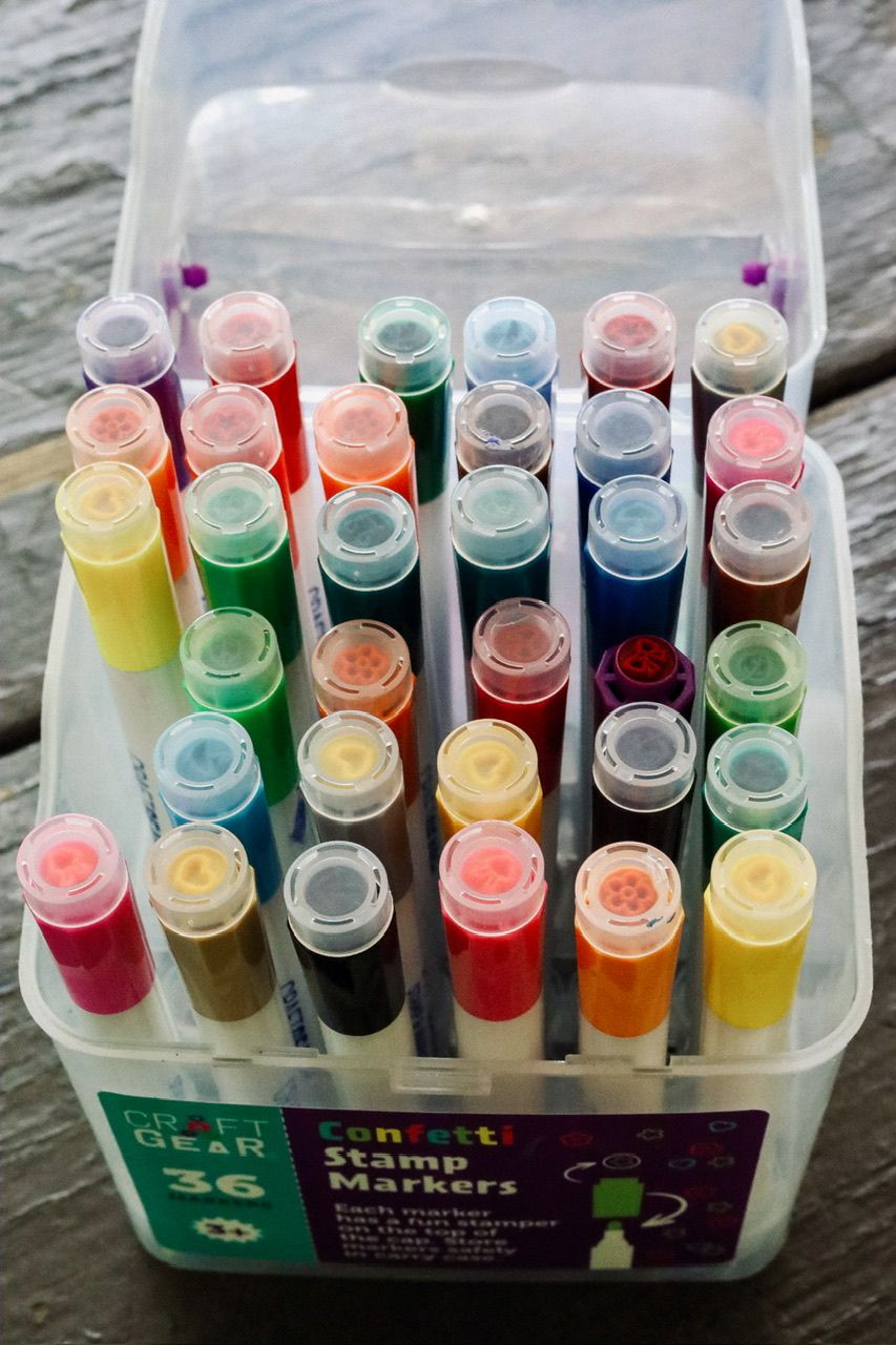 Colorful markers or stamps organized in a clear plastic storage container.