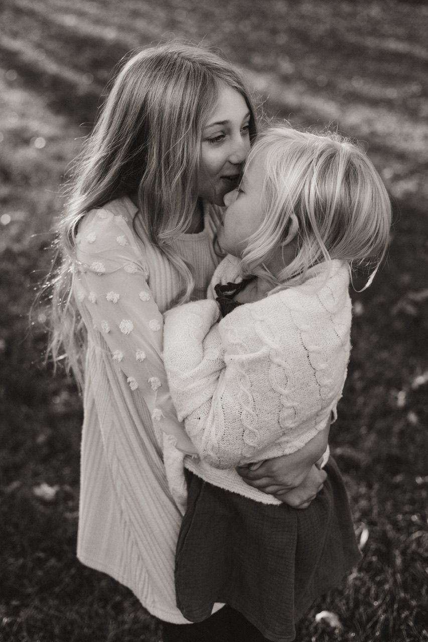 Black and white sequence of joyful embraces and laughter in an outdoor setting.