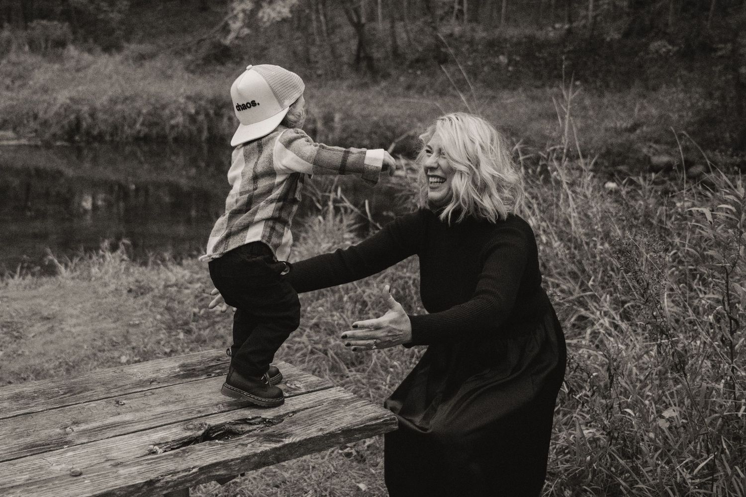 Monochrome image showing spontaneous play and connection near water's edge.