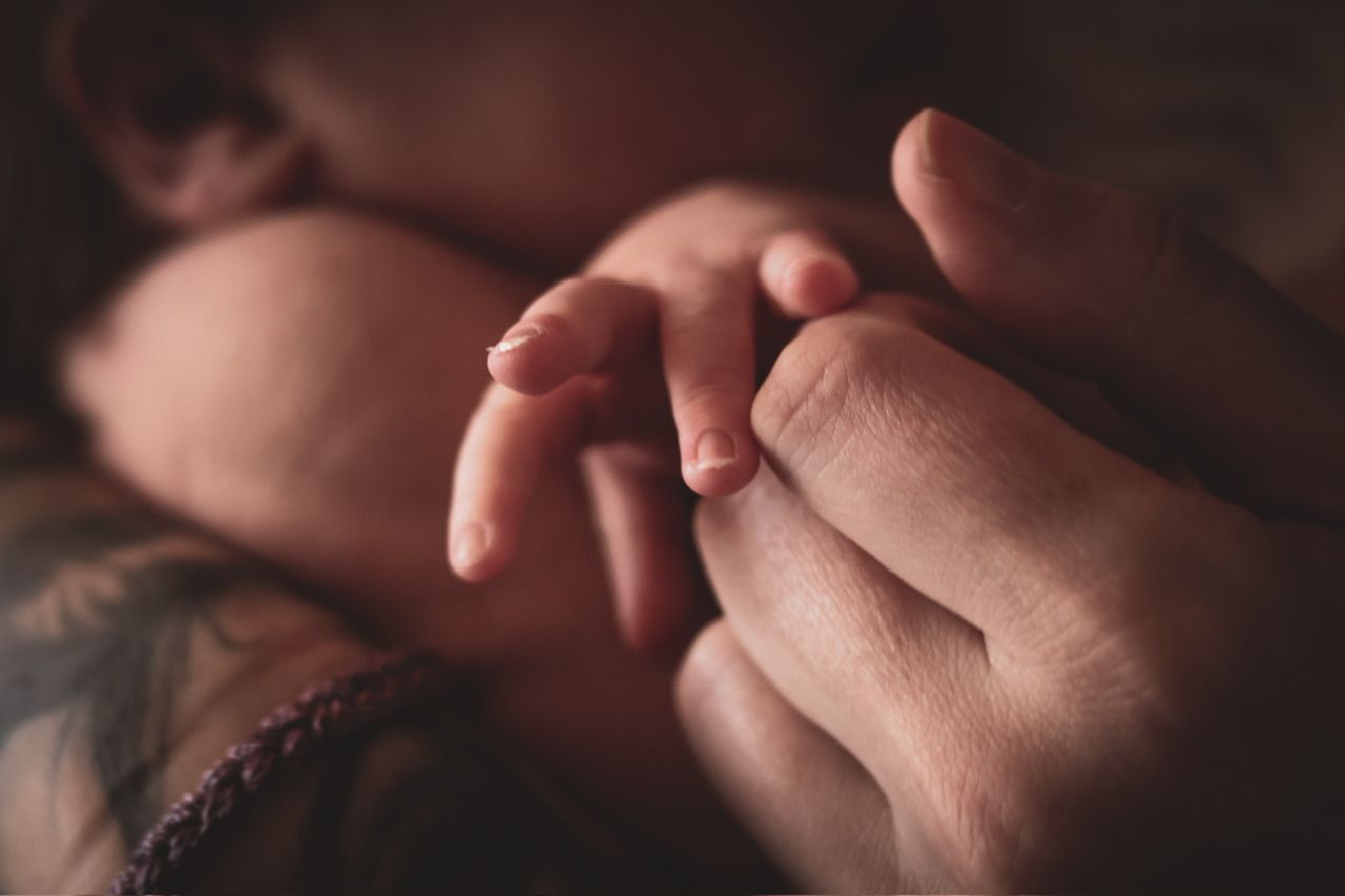Close-up macro shots of hands gently touching in a romantic sequence against a dark background.