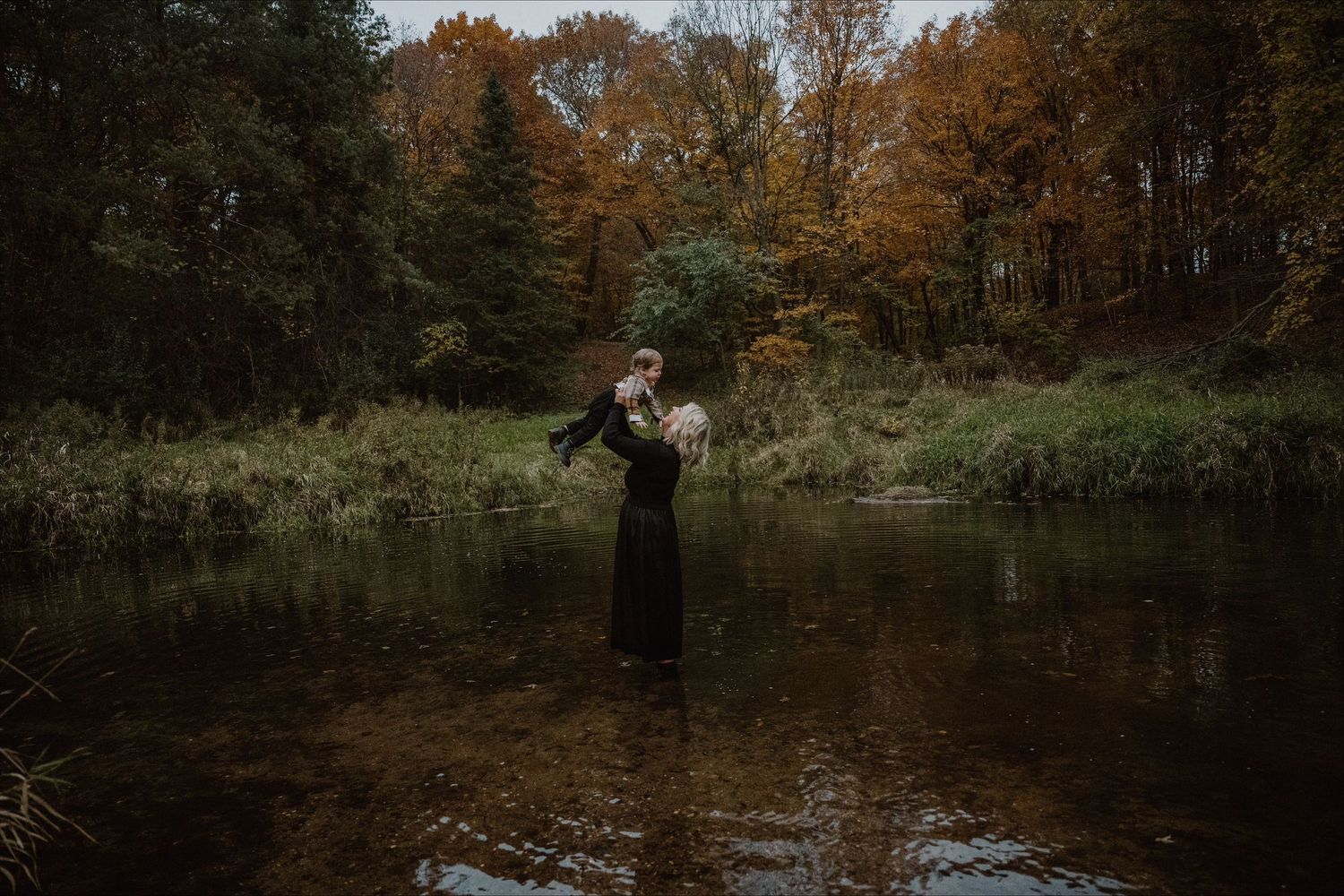 Serene autumn landscape with water reflections and fall foliage.