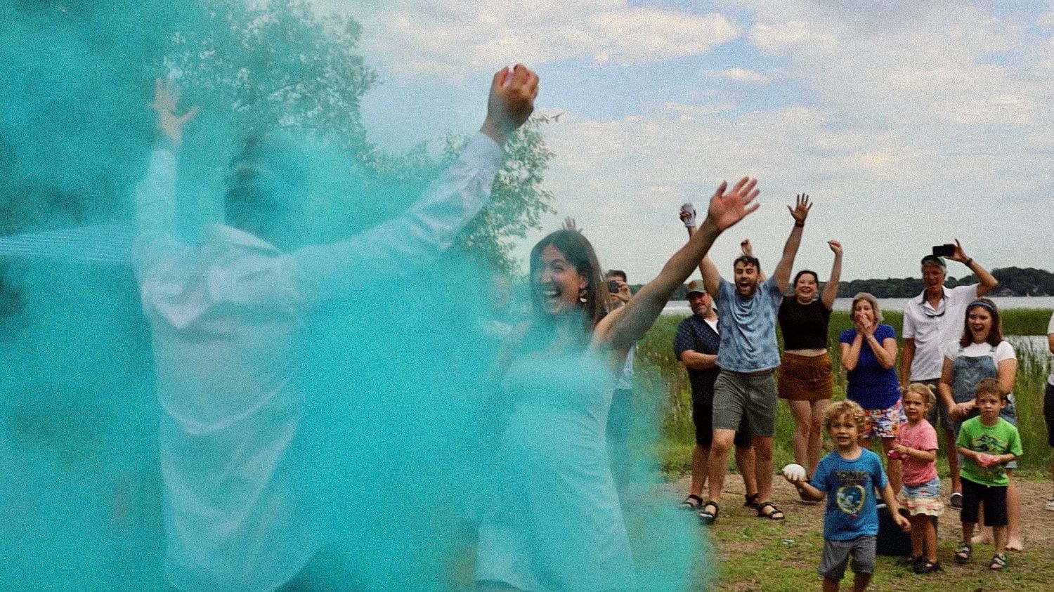 A joyous outdoor celebration with blue powder and gathered spectators.
