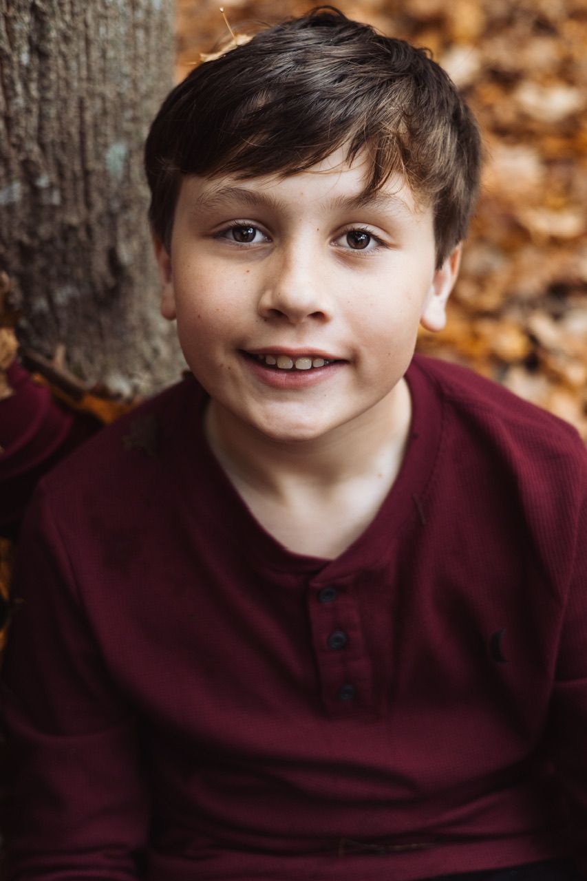 A series of five similar portraits showing a young child in a burgundy shirt against a blurred autumn background.