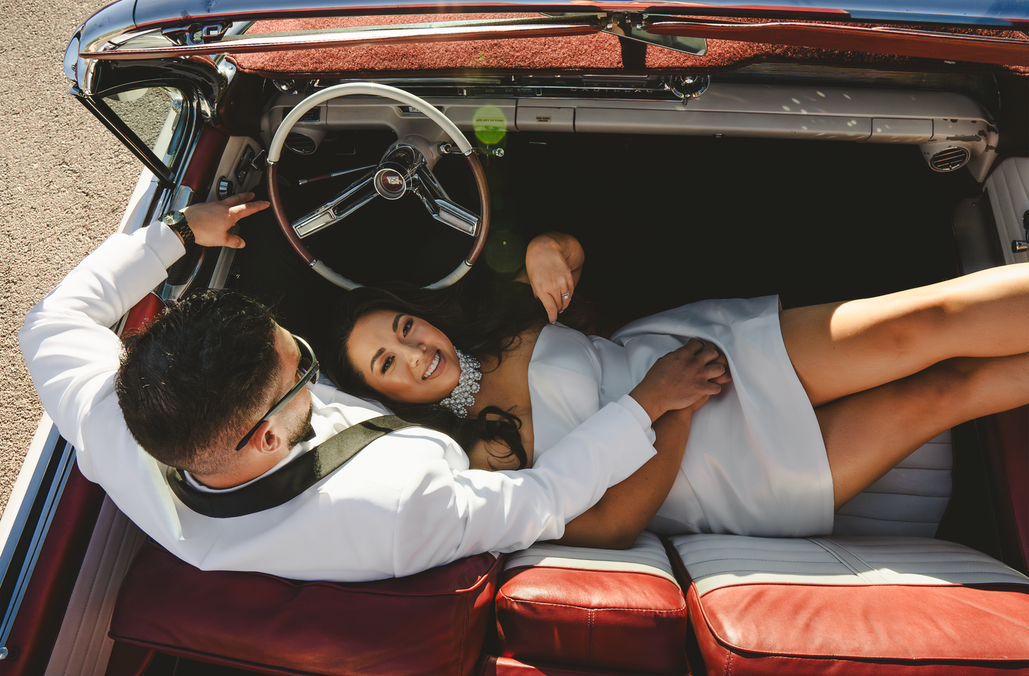 Relaxed moments captured inside a vintage car with desert landscape visible through windows.