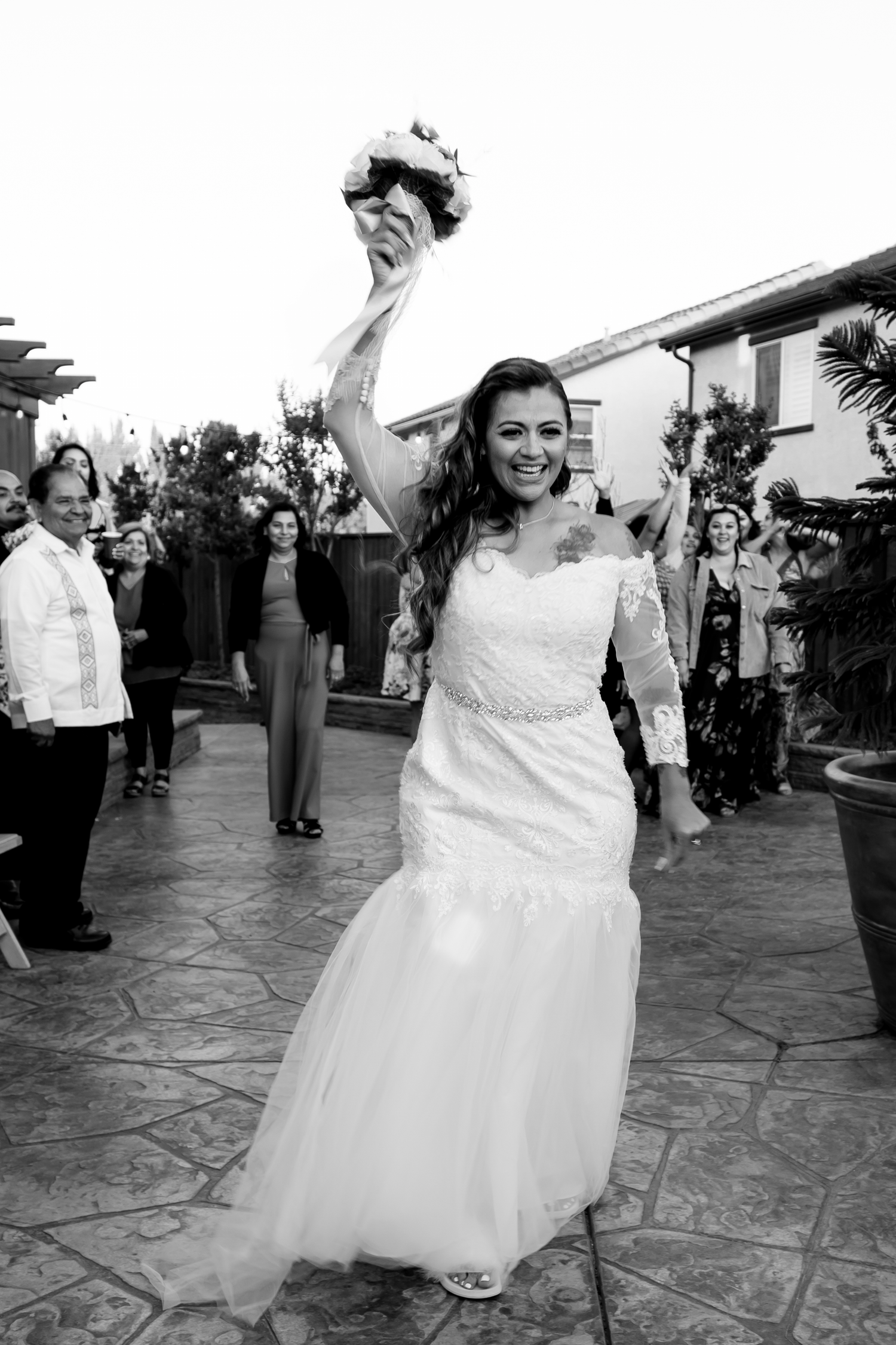 Joyful dancing celebration on an outdoor stone patio at a wedding reception.