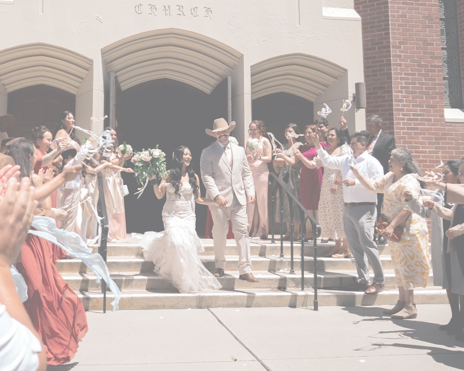 Outdoor celebration scene with guests in formal attire at church entrance.