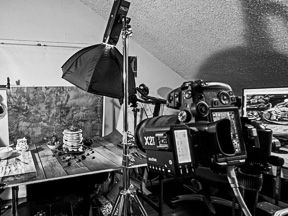 Professional photography studio setup with camera, lighting umbrella, and equipment.