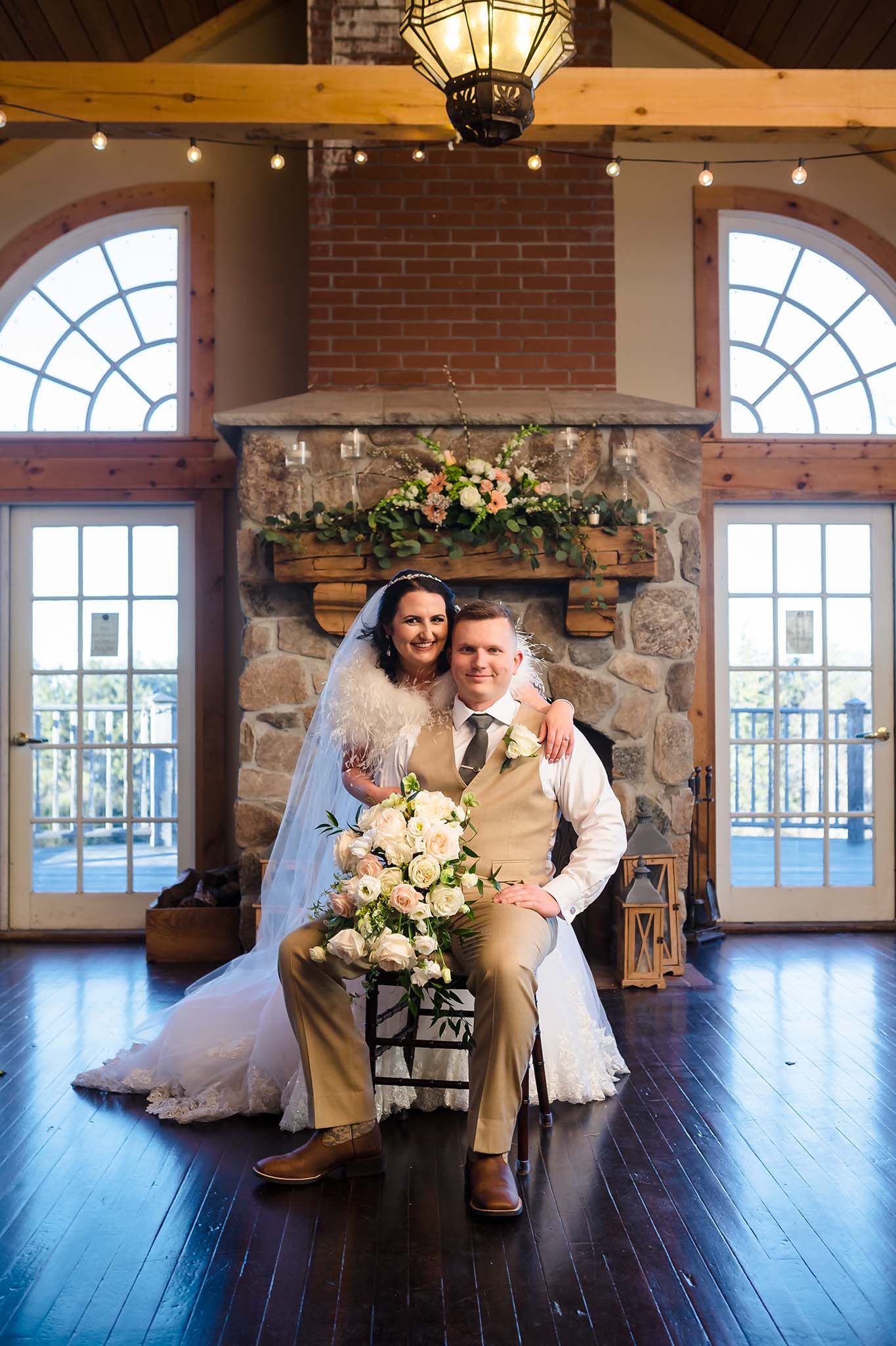 The bride  stands next to her seated husband for a formal portrait.