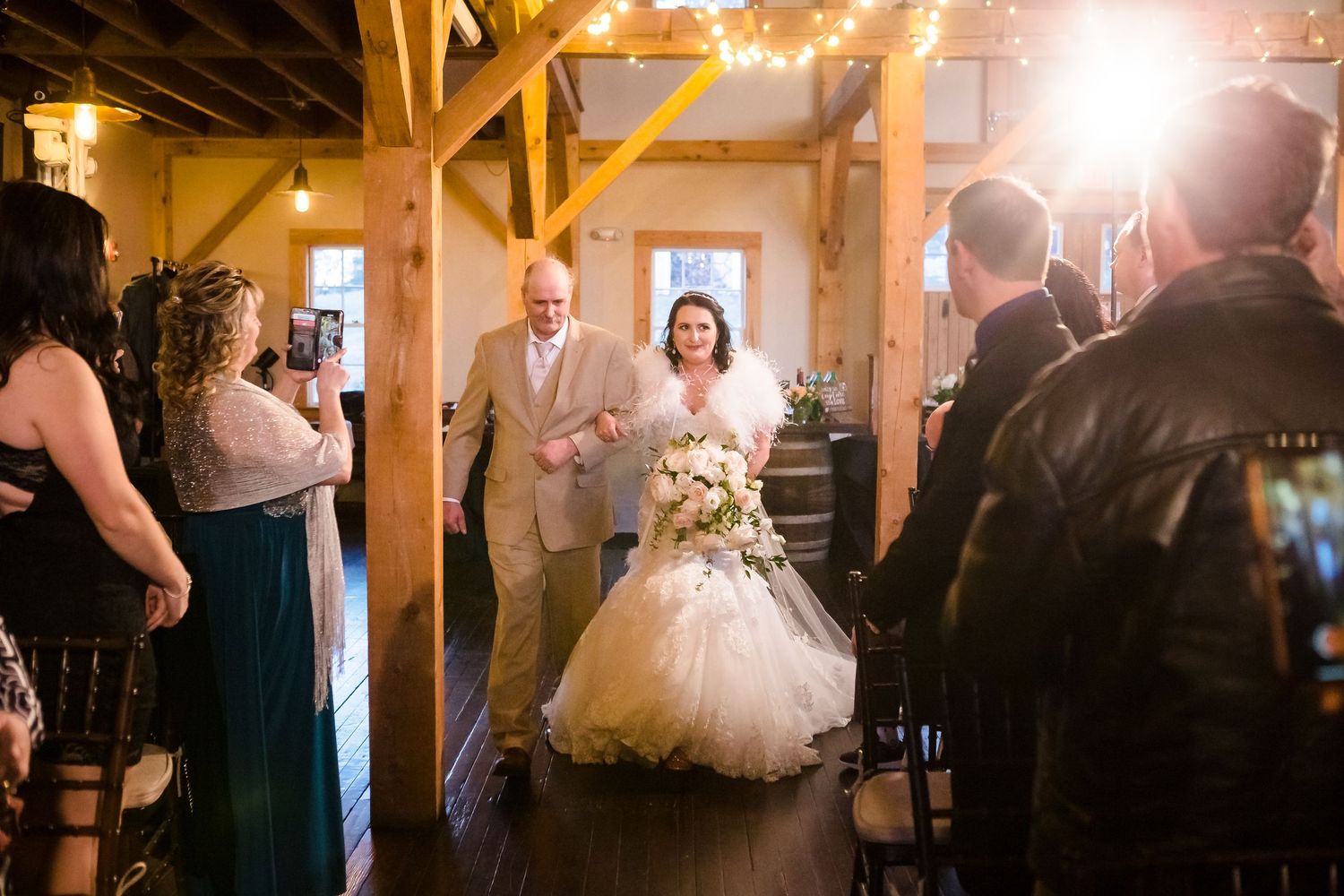 The  bride is walked down the aisle by her father in the Barn at the Peirce Farm Witch Hill